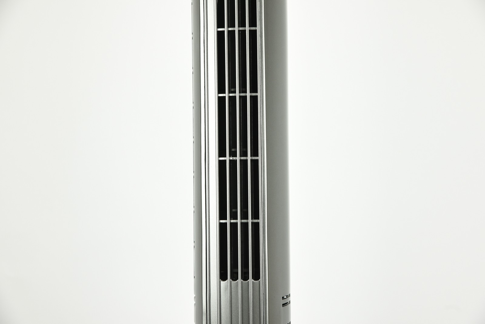 Zbliżenie pionowej kratki wentylatora z pionowymi metalowymi prętami.