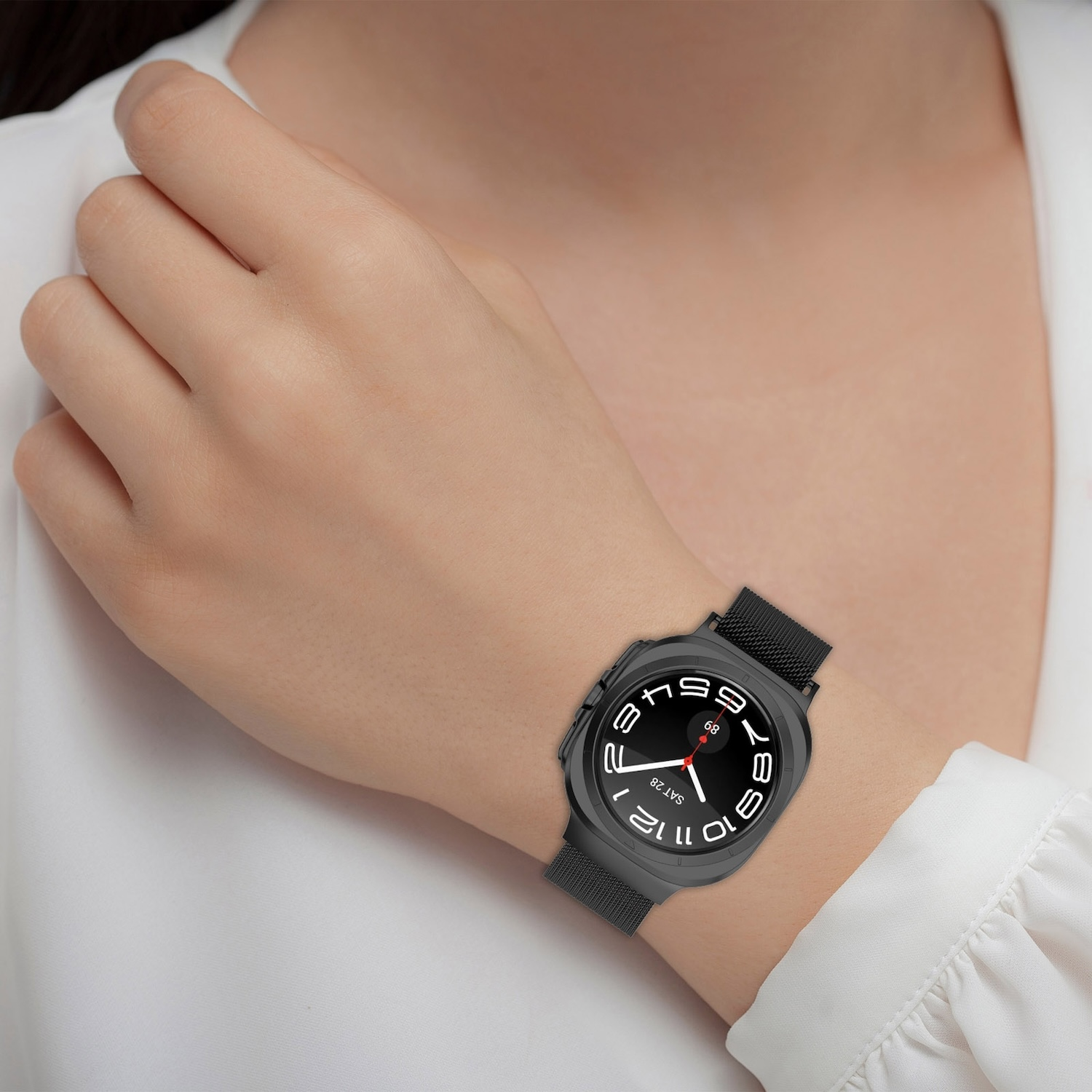 Handgelenk einer Frau mit einer schwarzen Smartwatch. Schwarzes Zifferblatt mit weißen Zahlen und ein schwarzes Armband.