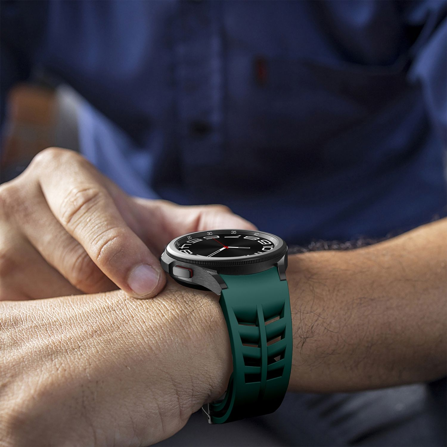 Eine schwarze Smartwatch an einem Handgelenk mit grünem Armband. Das Zifferblatt ist schwarz. Eine Hand ist sichtbar.