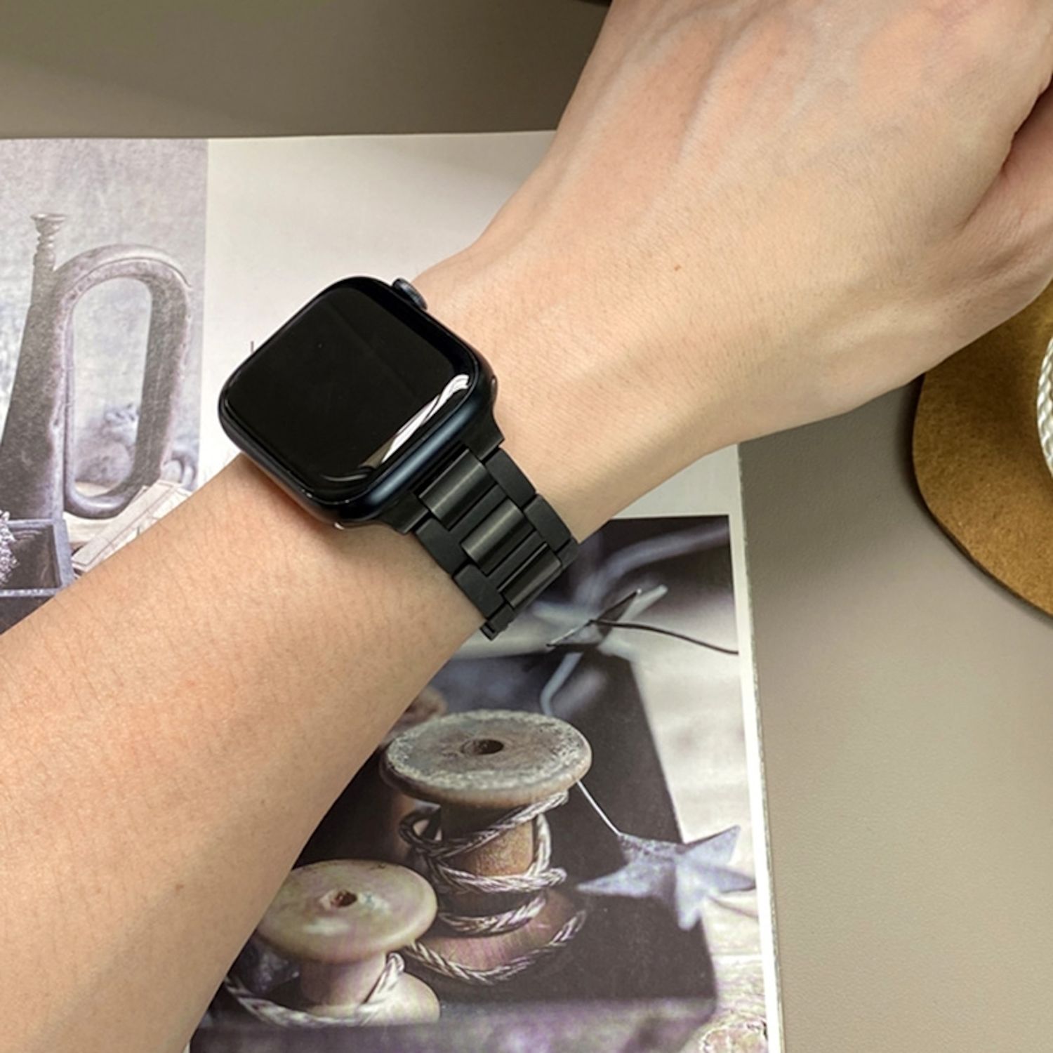 Eine Person, die eine schwarze Smartwatch an ihrem linken Handgelenk trägt. Die Uhr hat ein schwarzes Armband.