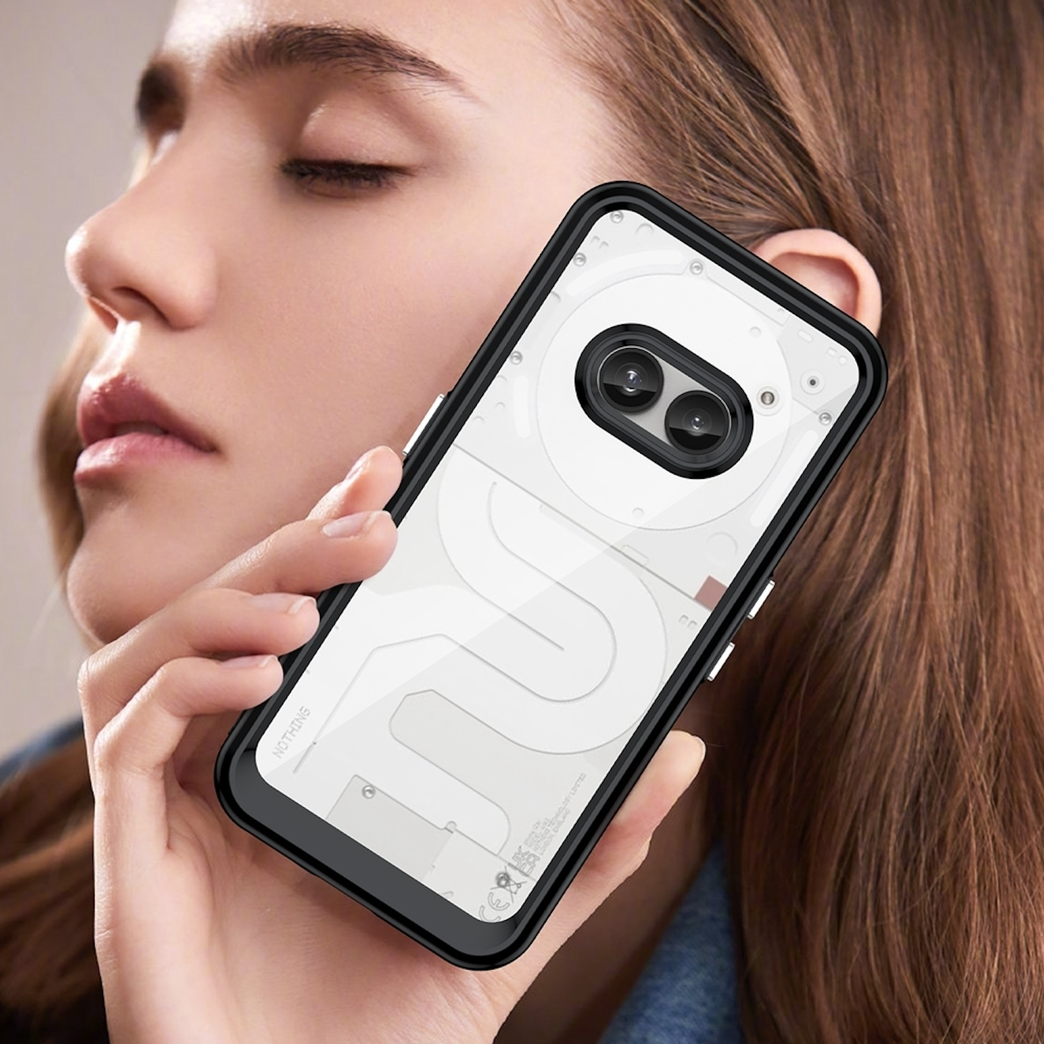 Frau hält ein Telefon in einem schwarzen Gehäuse. Telefon hat eine weiße Rückseite.