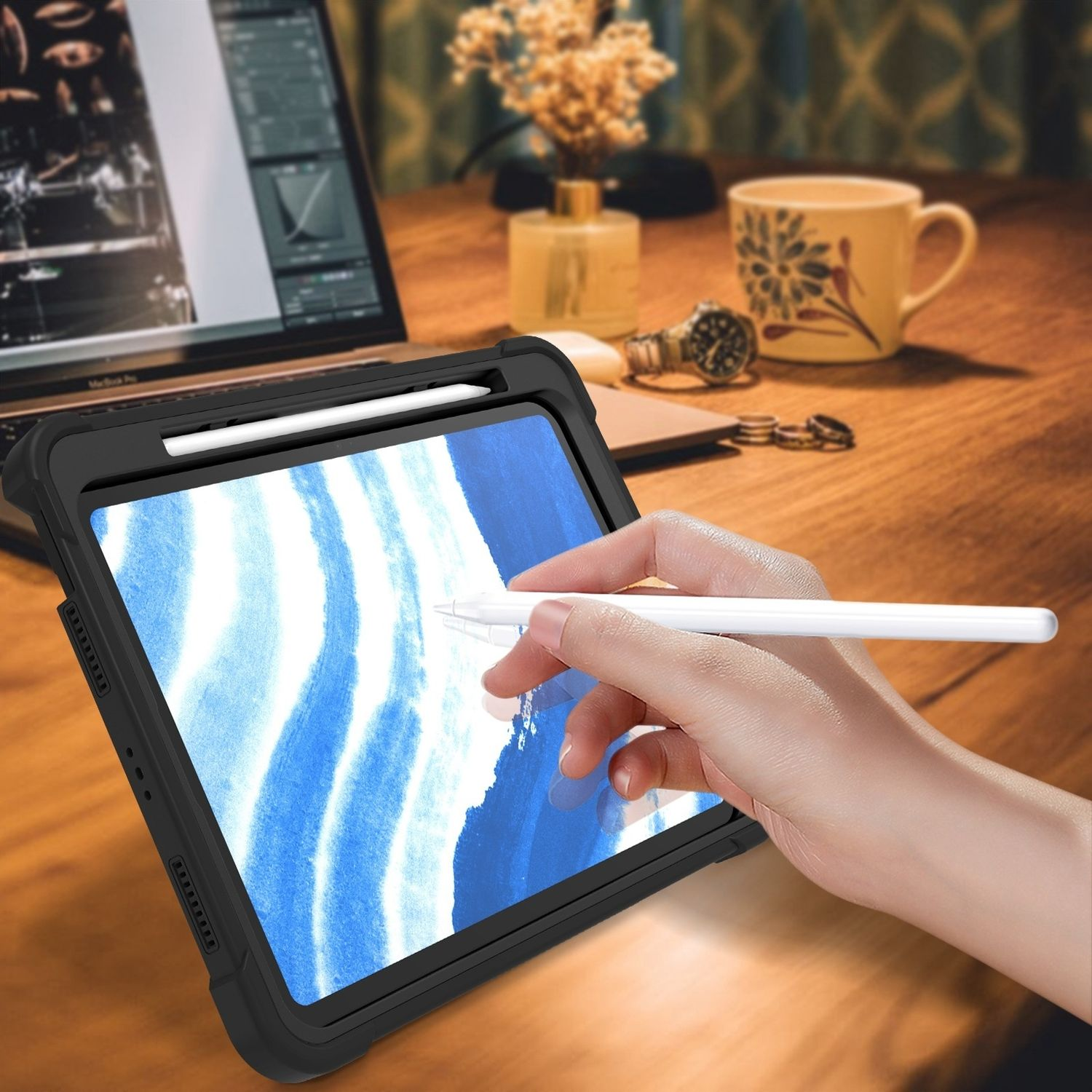 Person verwendet einen Stift auf einem Tablet. Das Tablet befindet sich in einer schwarzen Schutzhülle. Schreibtischgegenstände im Hintergrund.