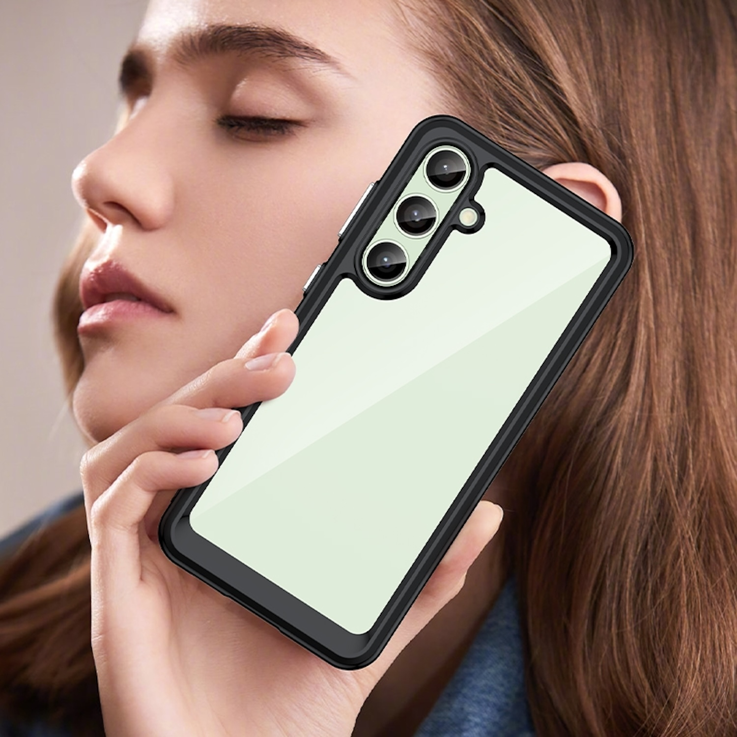 Eine Frau, die ein Telefon hält, das von einer schwarzen und transparenten Handyhülle bedeckt ist. Das Telefon hat drei Kameras.