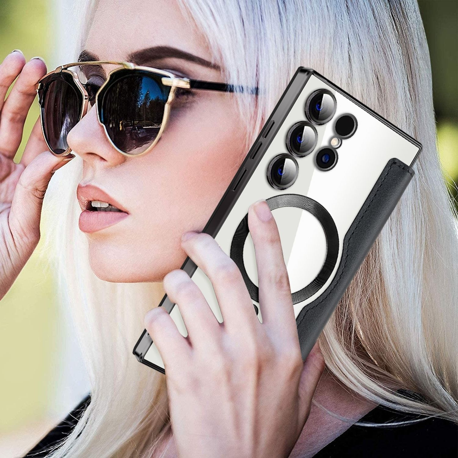 Blonde Frau mit Sonnenbrille hält ein Telefon mit weißem und schwarzem Gehäuse.