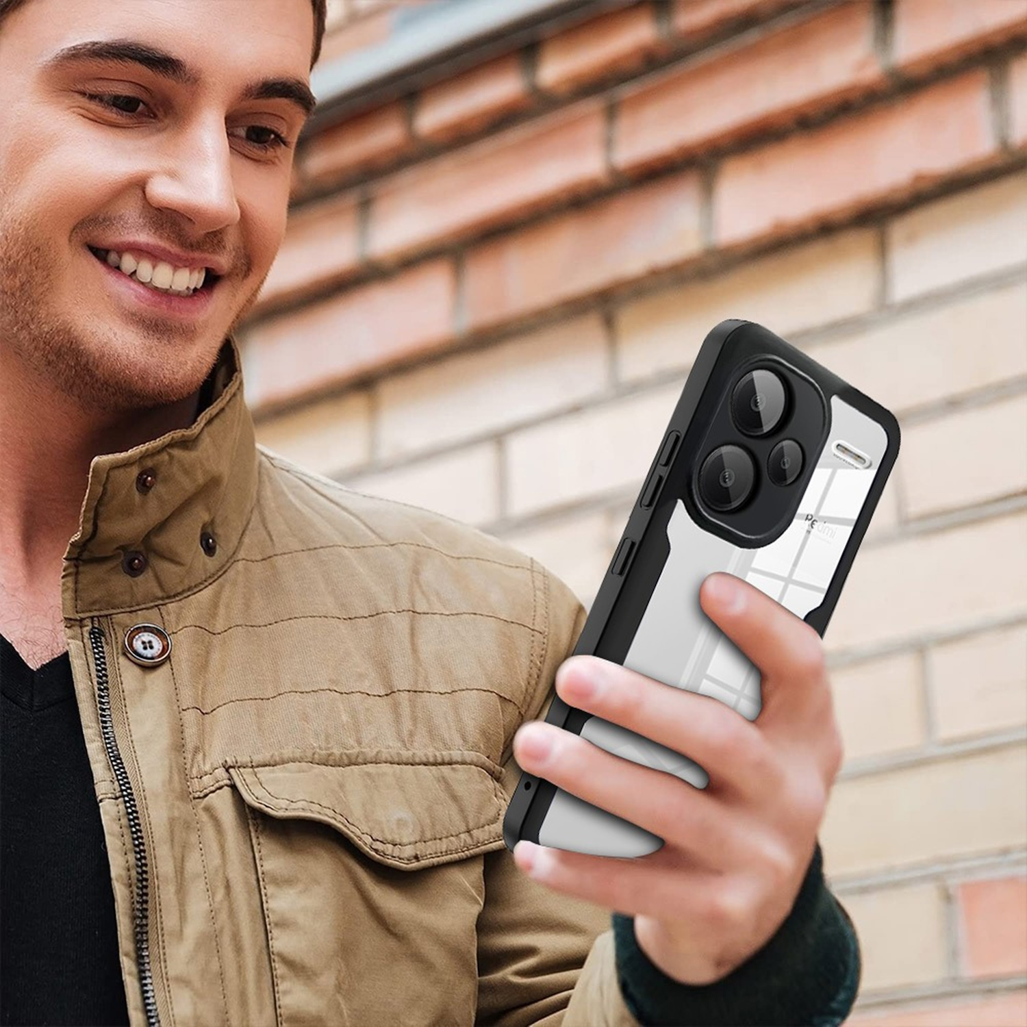 Mann hält schwarze und transparente Handyhülle. Zeigt ein Telefon.