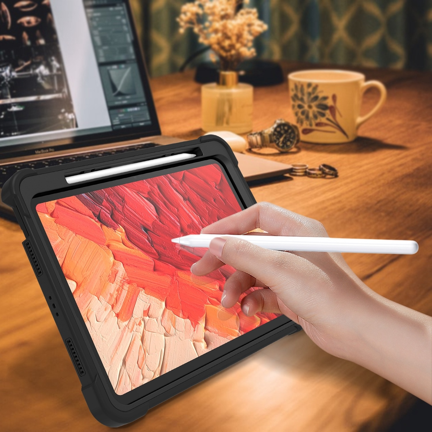 Ein Tablet mit schwarzer Hülle und Stift. Hintergrund zeigt Schreibtischaufbau.