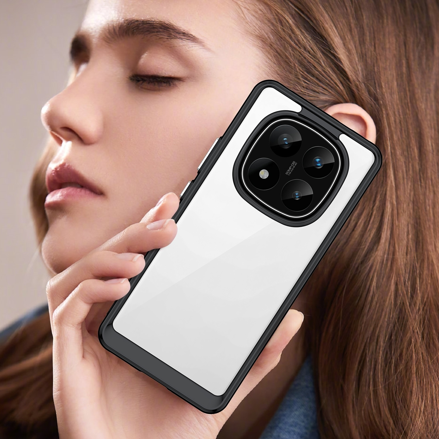Una mujer sosteniendo un teléfono en una funda transparente. La funda del teléfono es negra con borde blanco.