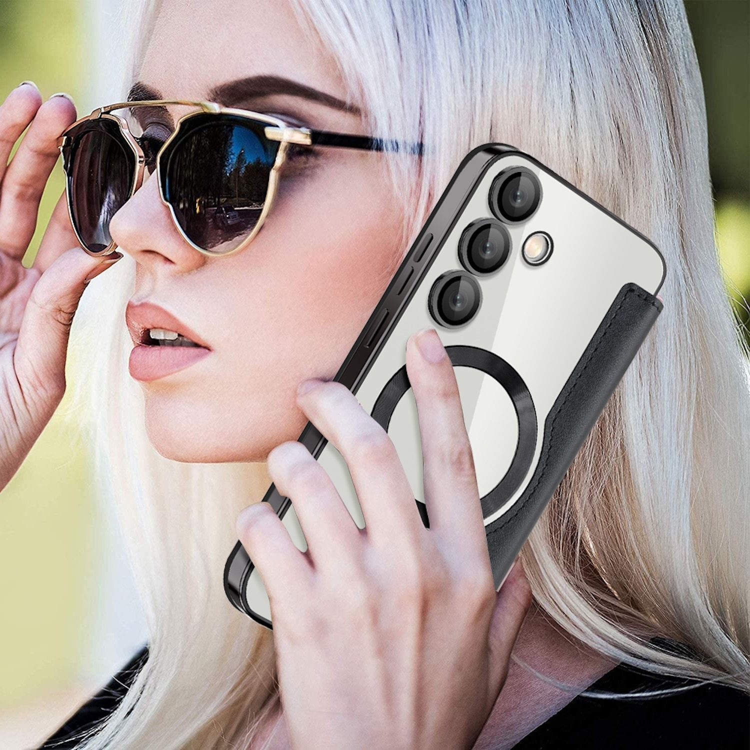 Eine Frau hält ein Telefon in einer transparenten Hülle mit schwarzem Leder. Sie trägt eine Sonnenbrille.