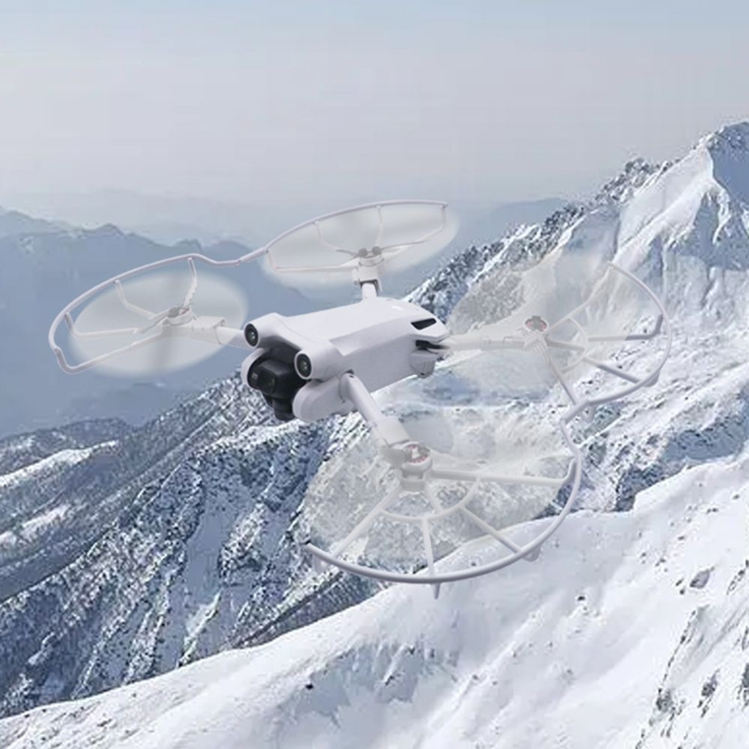 Weiße Drohne fliegt über verschneite Berge.