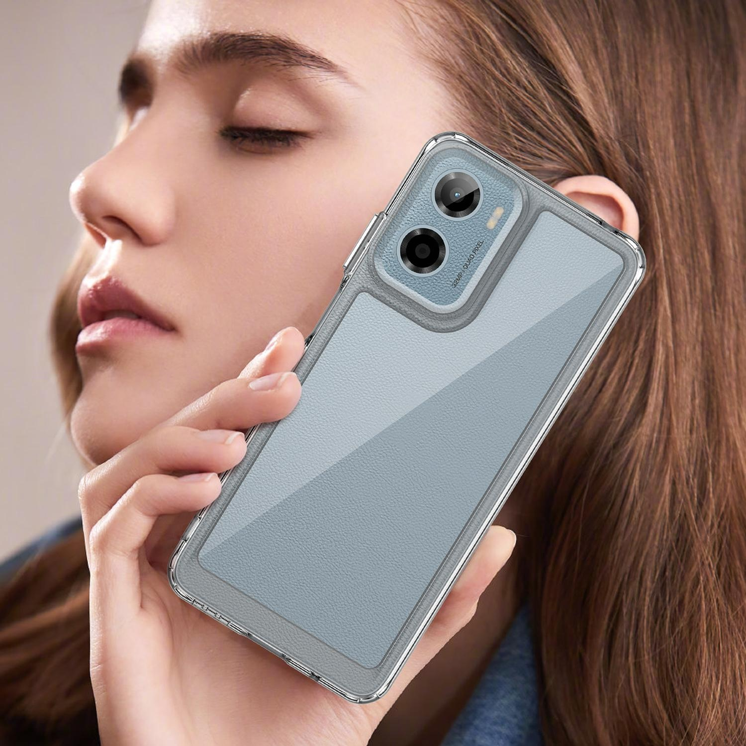 Mujer sosteniendo una funda de teléfono gris con un teléfono dentro. La mujer sostiene el teléfono frente a su rostro.