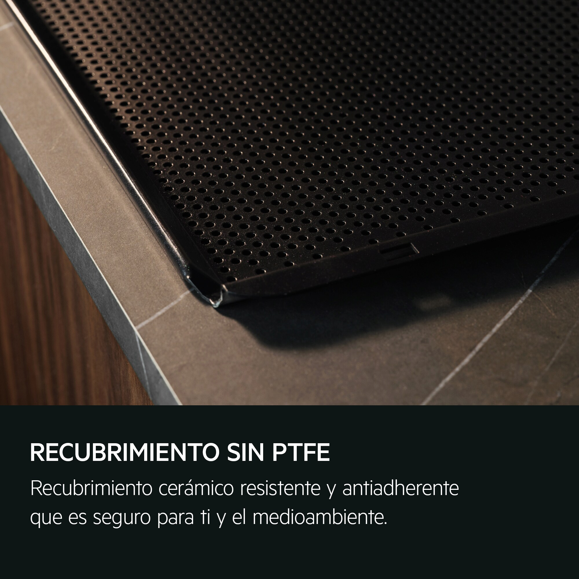 Primer plano de una bandeja negra con agujeros. El texto dice: "Revestimiento sin PTFE".