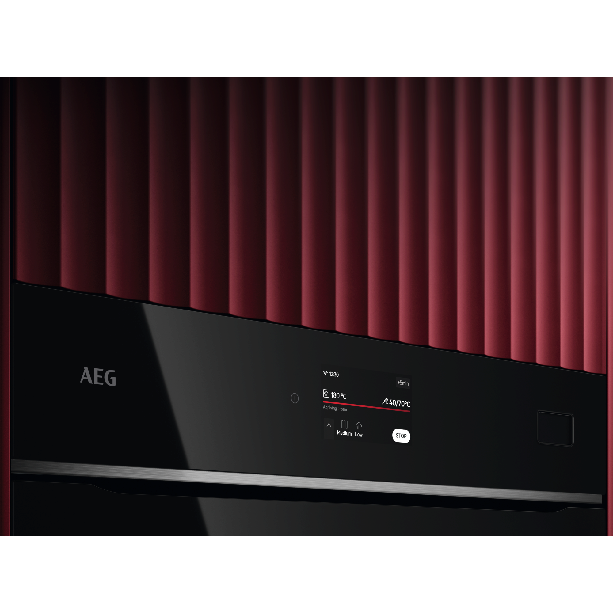 Primo piano di forno nero con pannello rosso. Display mostra 180C e 40/70C.