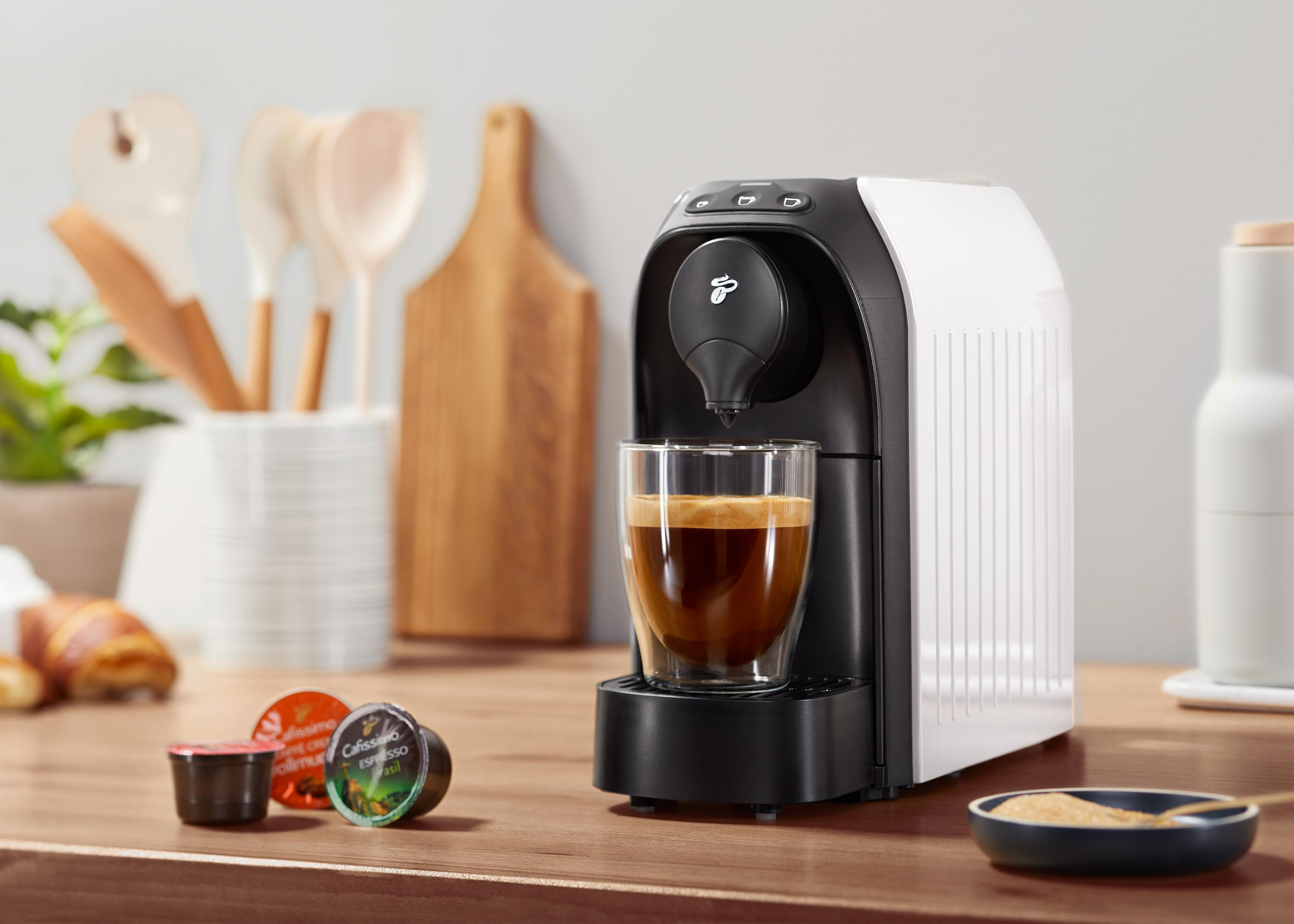Kaffeemaschine mit einer Tasse Kaffee auf einer Küchentheke. Es gibt Kaffeepads.