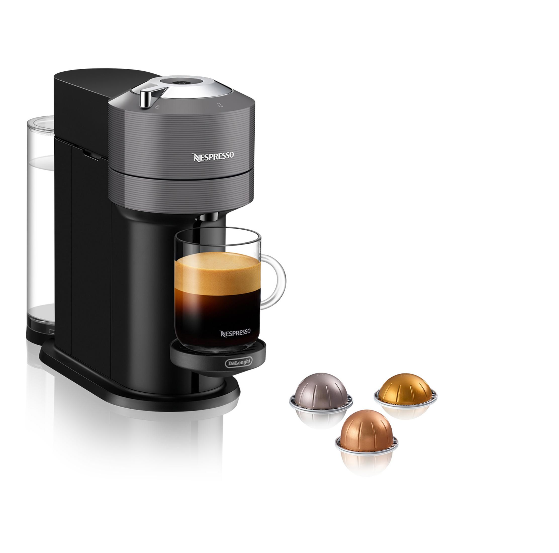 Schwarz-graue Nespresso-Maschine mit Kaffee im Glas und Kapseln.