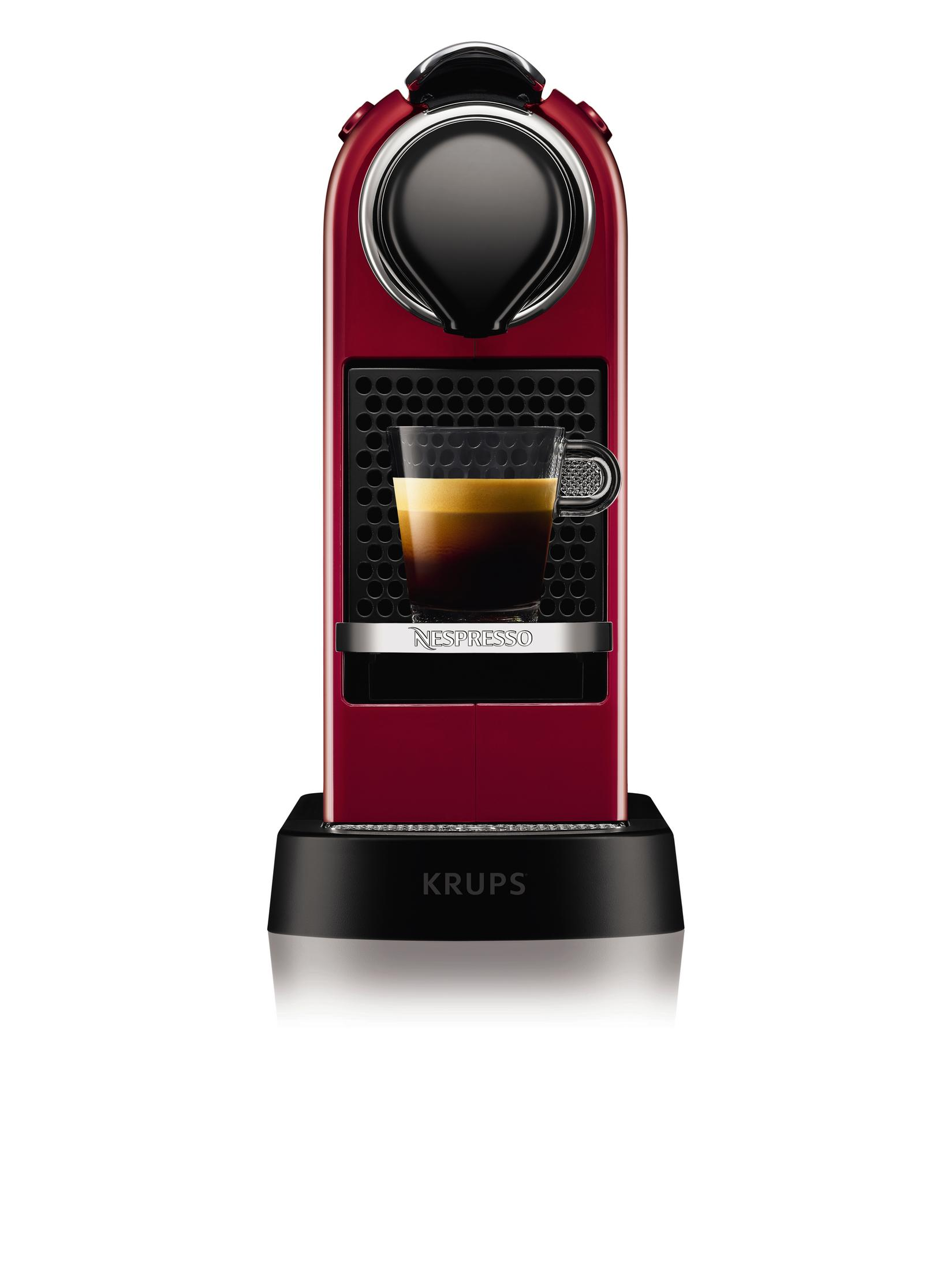 Czerwony ekspres Nespresso z filiżanką kawy. Czarna podstawa i góra. Białe tło.