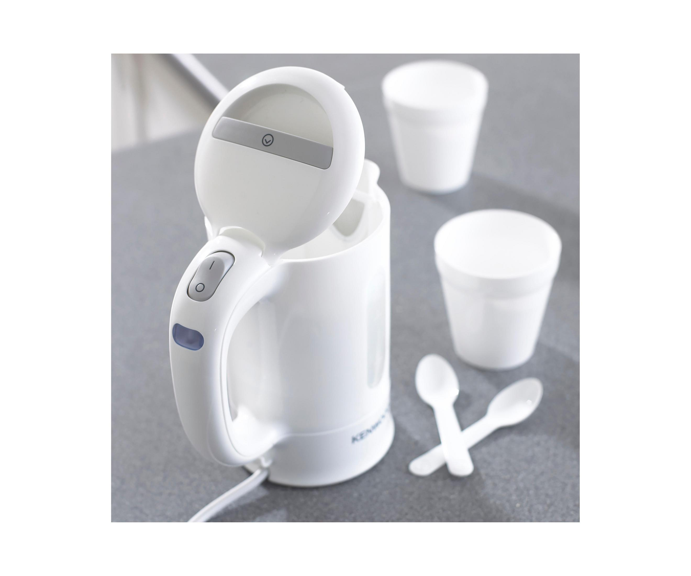 Ein weißer Kenwood Reise-Wasserkocher mit Bechern und Löffeln, auf grauer Oberfläche. Der Deckel ist offen.