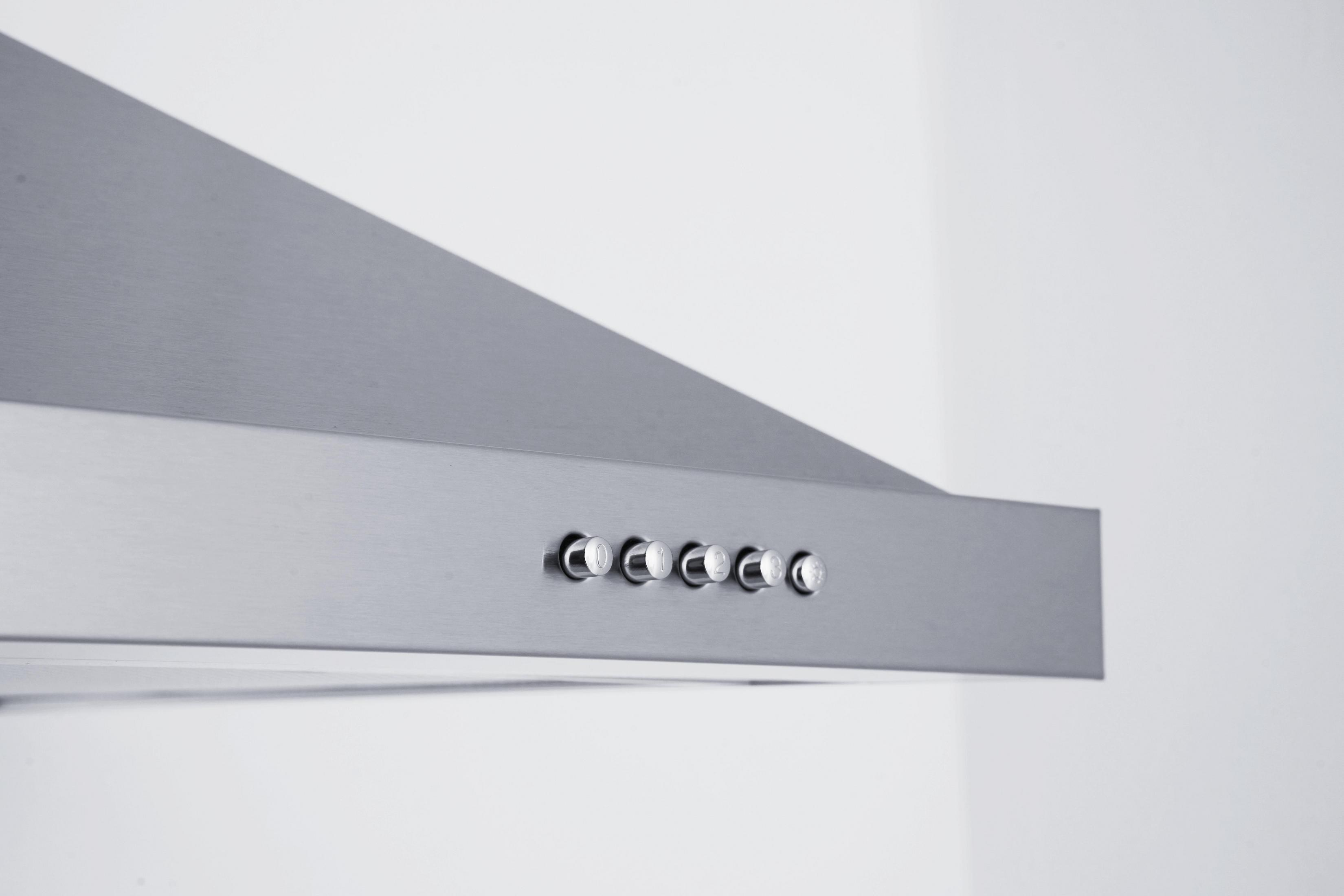 Close-up of a range hood's control buttons on a stainless steel surface.