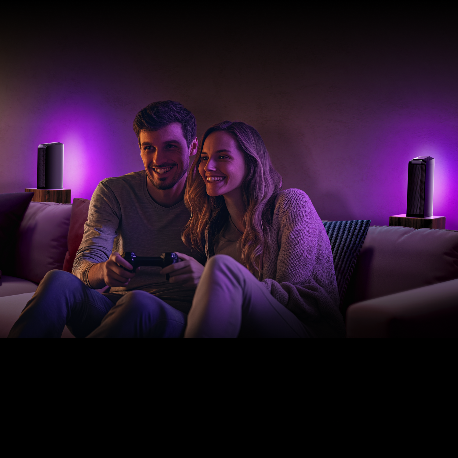 Para grająca w grę. Dwa głośniki na stojakach z fioletowymi światłami. Pokój jest ciemny.
