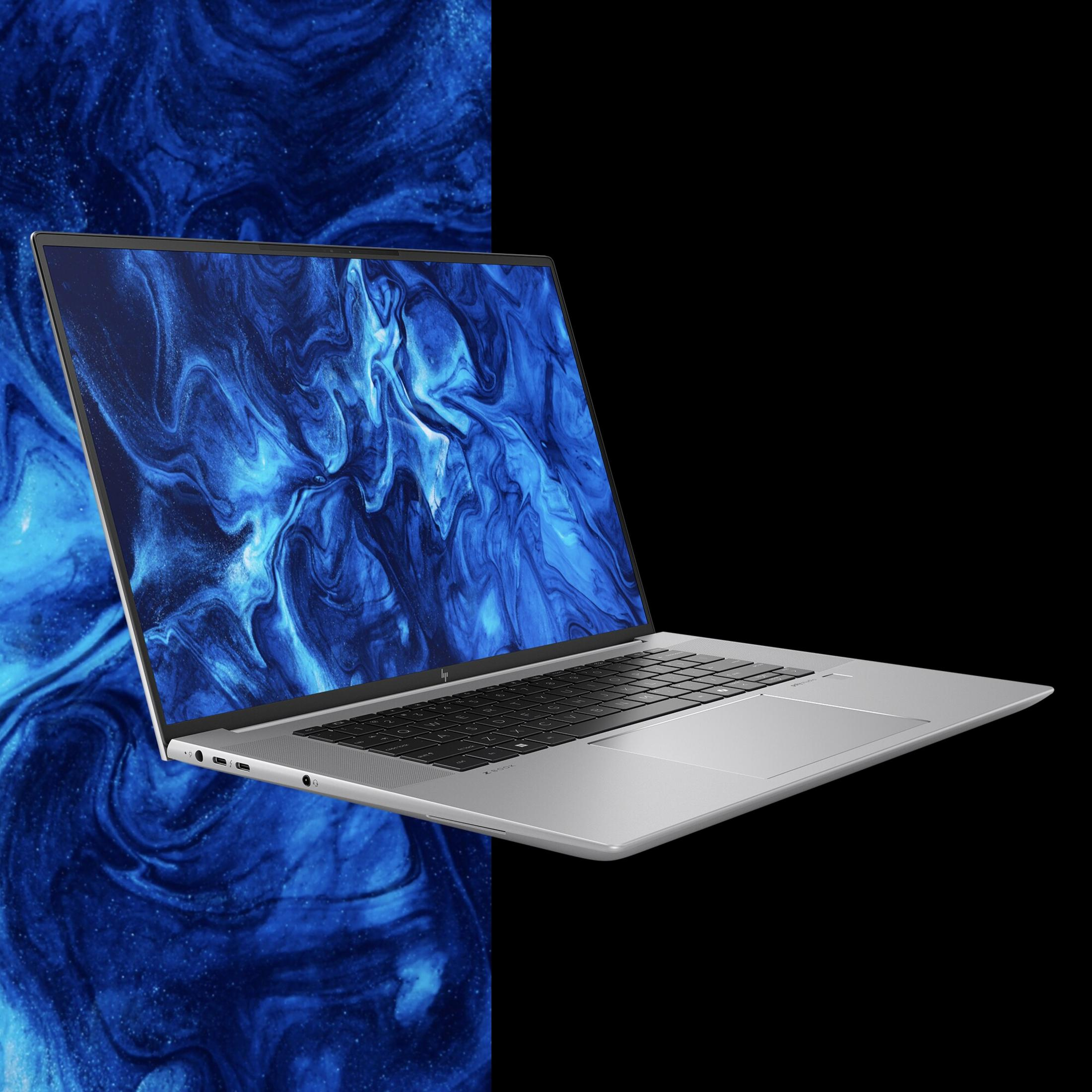 Silberner Laptop mit blauem und schwarzem abstraktem Design auf dem Bildschirm, geöffnet in einem Winkel.