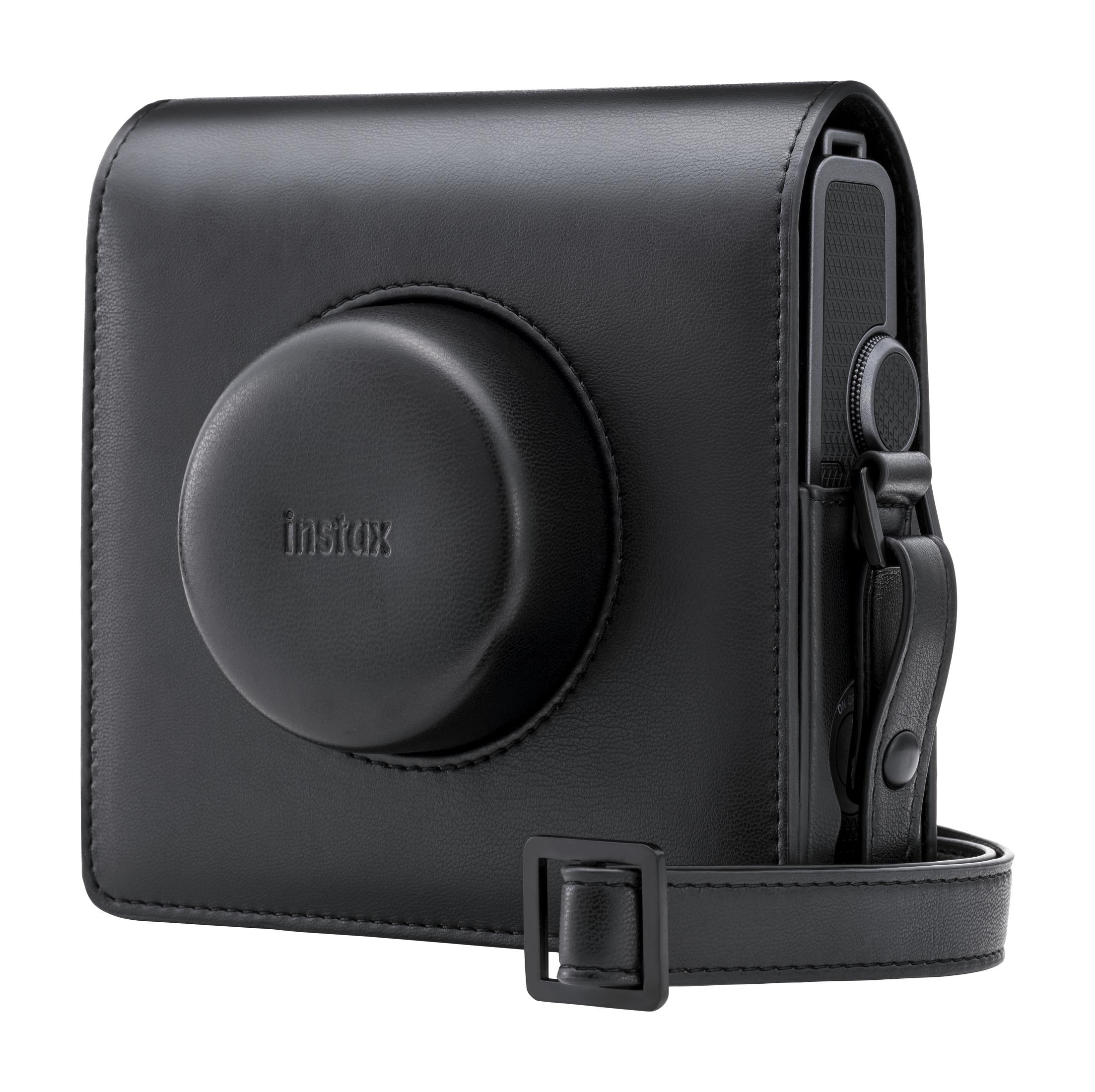 Schwarze Leder-Kameratasche mit Instax-Logo und Kamera im Inneren. Riemen und Schnalle sichtbar.