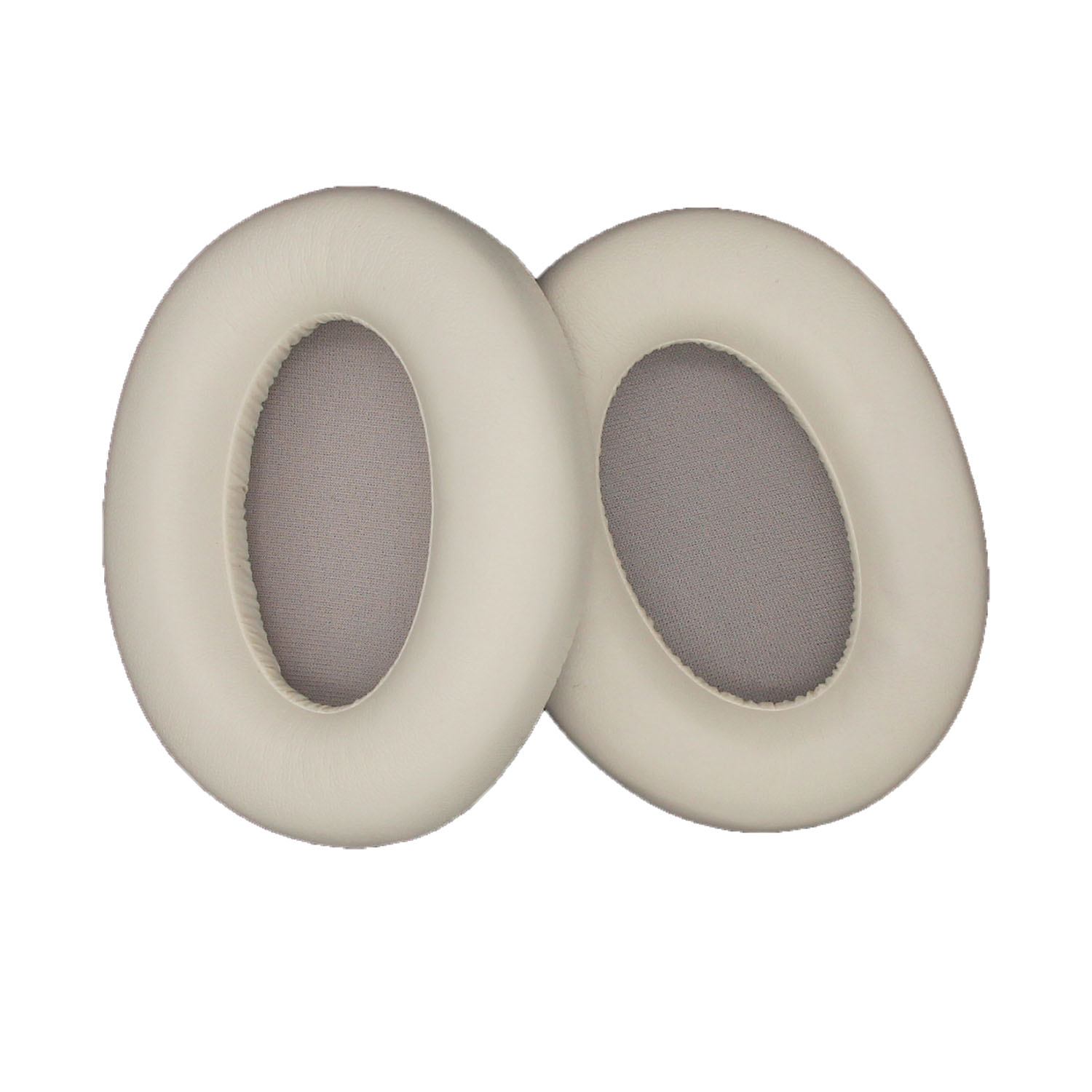 Due cuscinetti auricolari per cuffie di colore chiaro, rotondi con centro grigio, isolati su bianco.