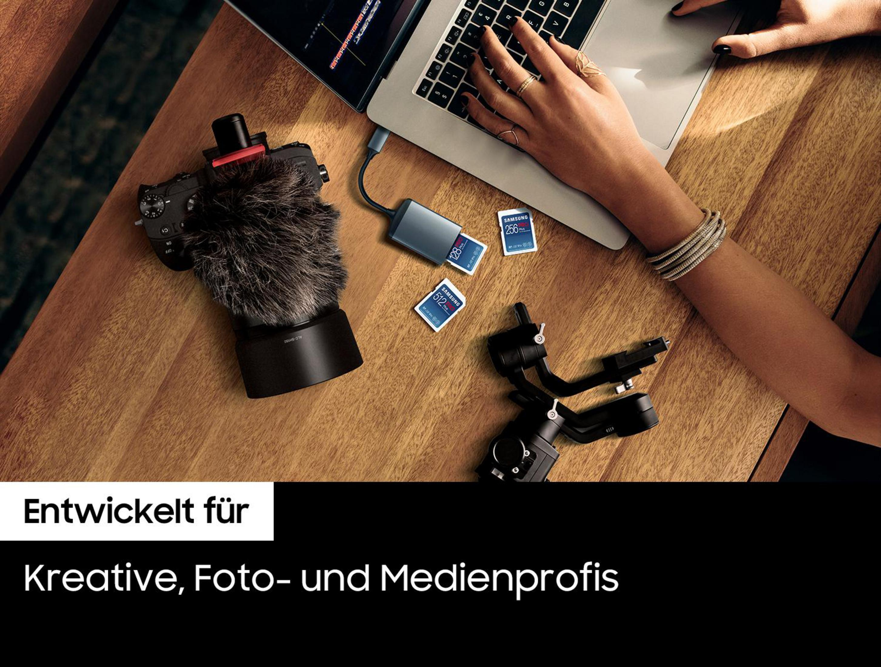 Ręce pracują z kamerą, mikrofonem, kartami SD i laptopem na drewnianym stole.