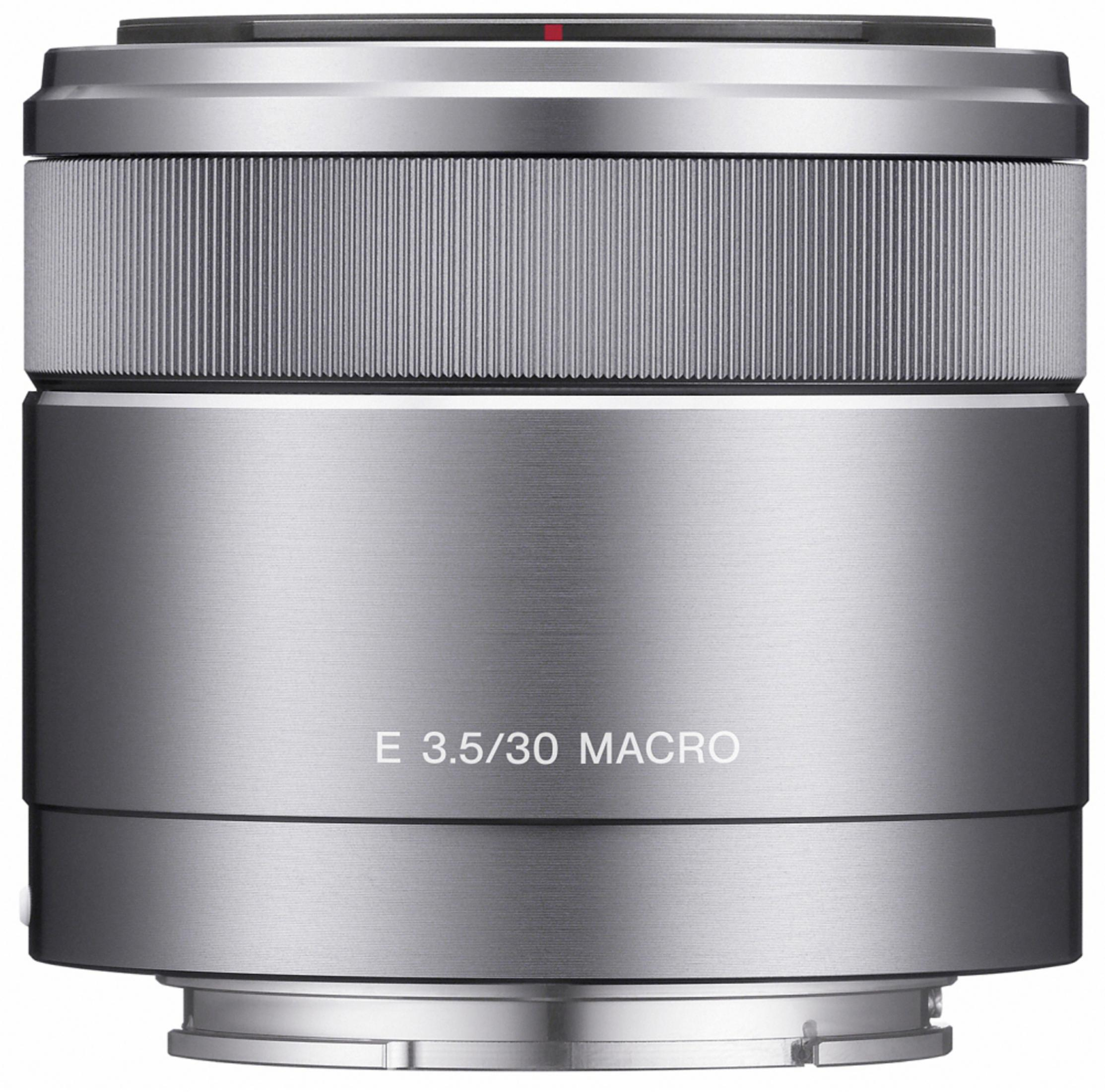 Srebrny obiektyw aparatu z czarnymi detalami, tekst E 3.5/30 MACRO. Izolowany na białym tle.