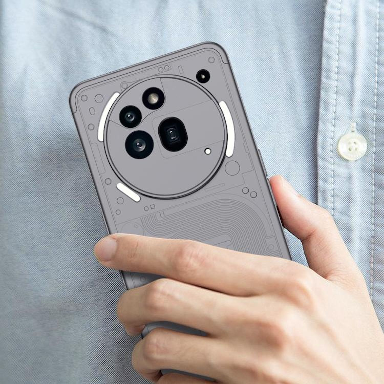 Mano sosteniendo teléfono con funda, mostrando la parte trasera con lentes de cámara. Fondo gris y azul claro.