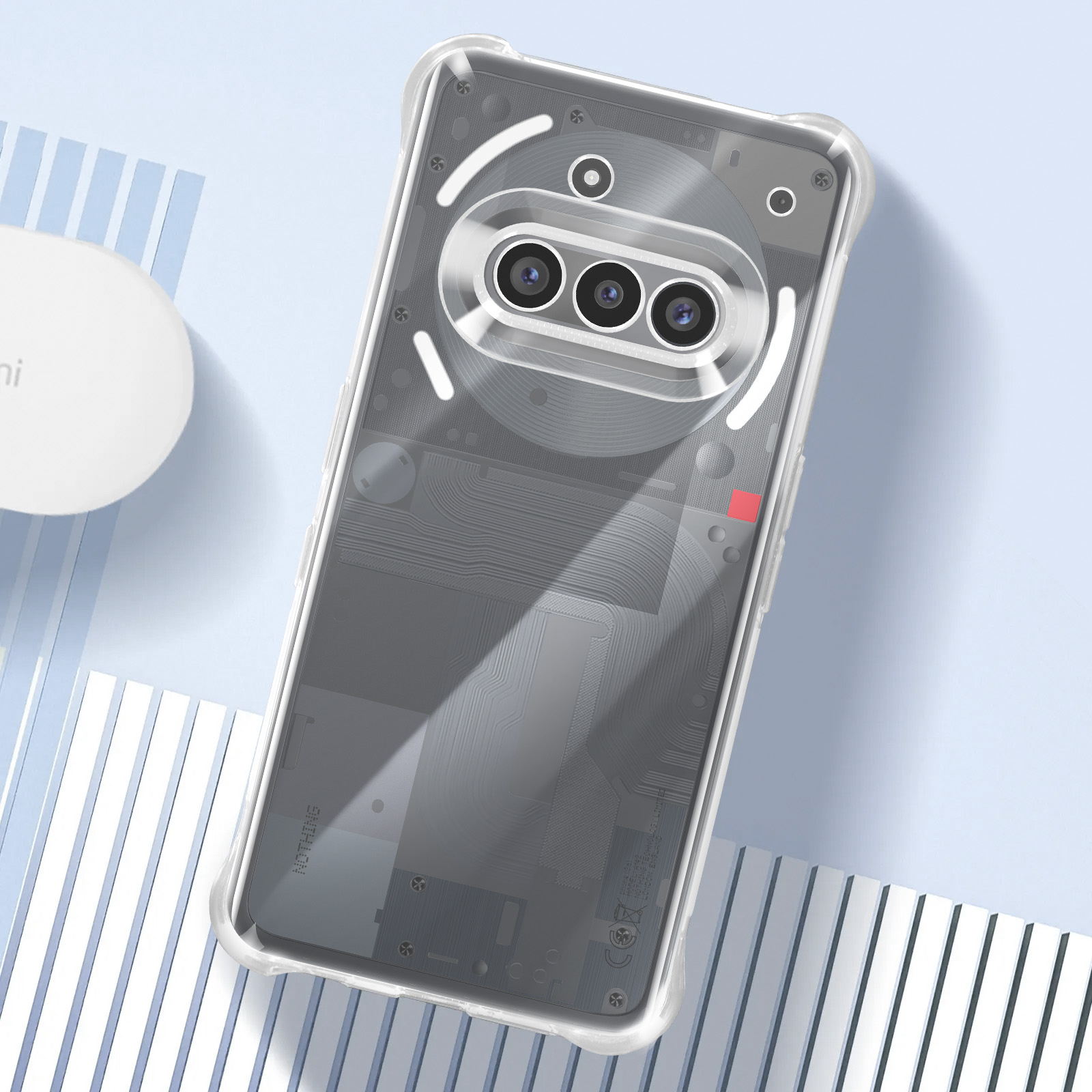 Coque de téléphone transparente, montrant les composants internes du téléphone. Objet rond à gauche.