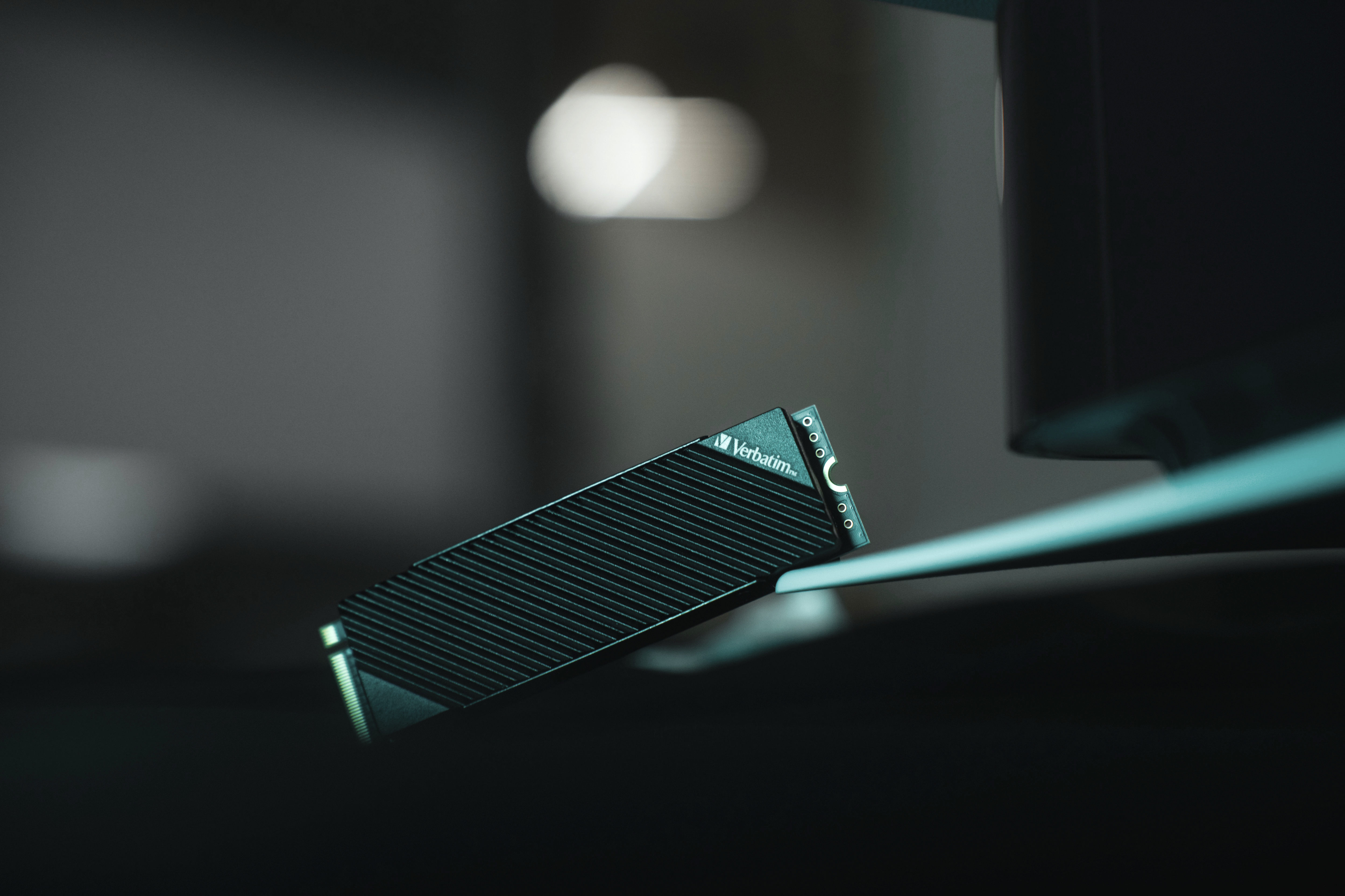 Czarny zewnętrzny dysk SSD Verbatim, pod kątem, na powierzchni, z rozmytym tłem.