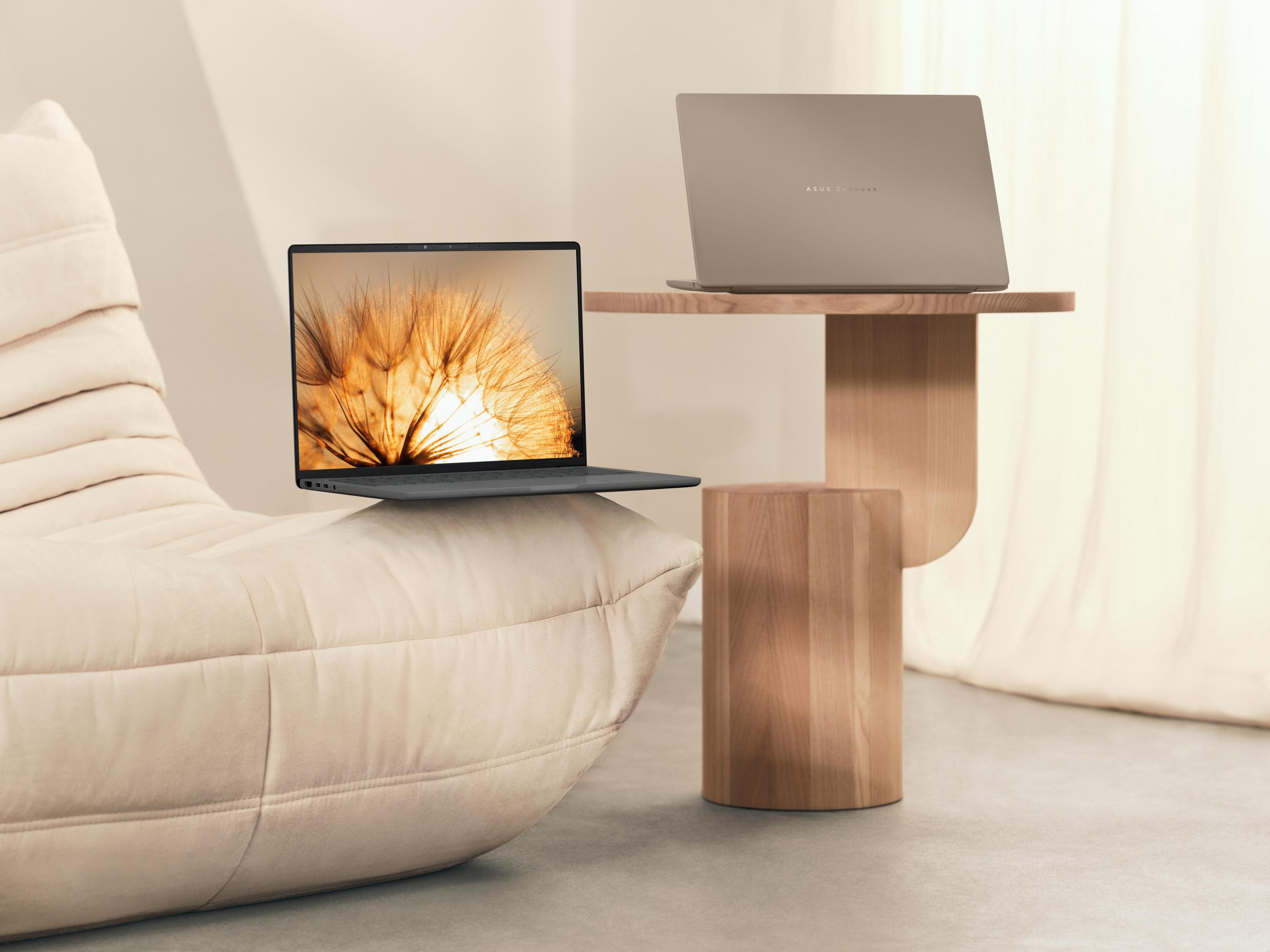 Zwei Laptops auf beigem Sofa und Tisch. Einer offen, zeigt Löwenzahnbild. Neutraler Hintergrund.