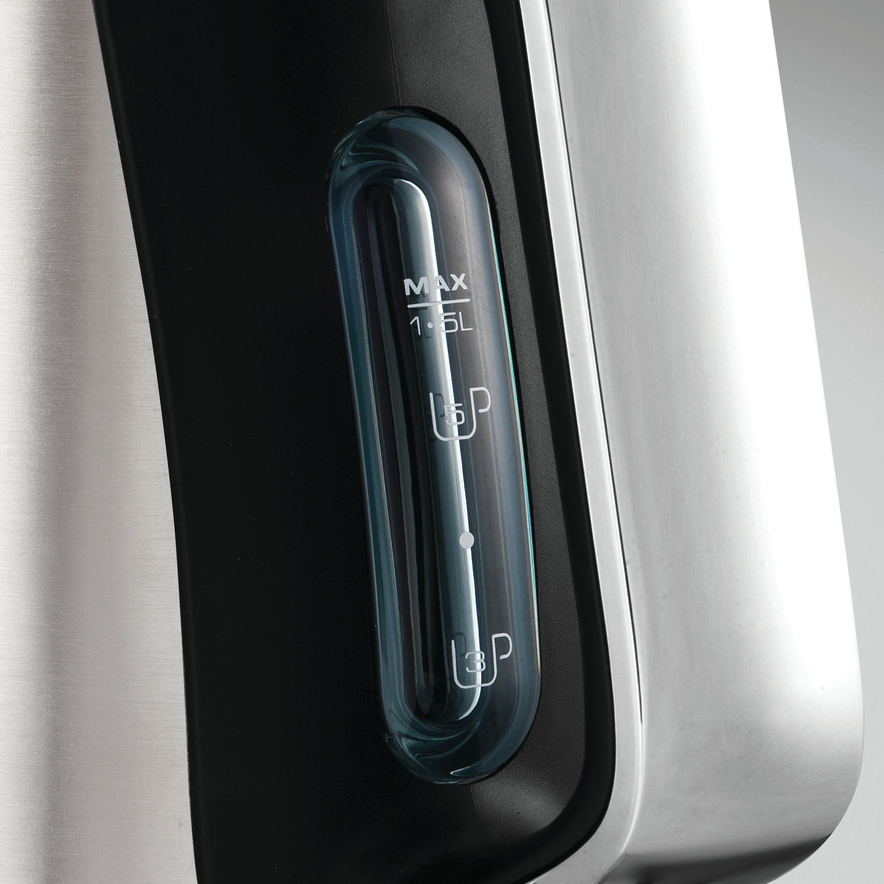 Zbliżenie wskaźnika poziomu wody w czajniku. Srebrny czajnik, czarny i niebieski wskaźnik.