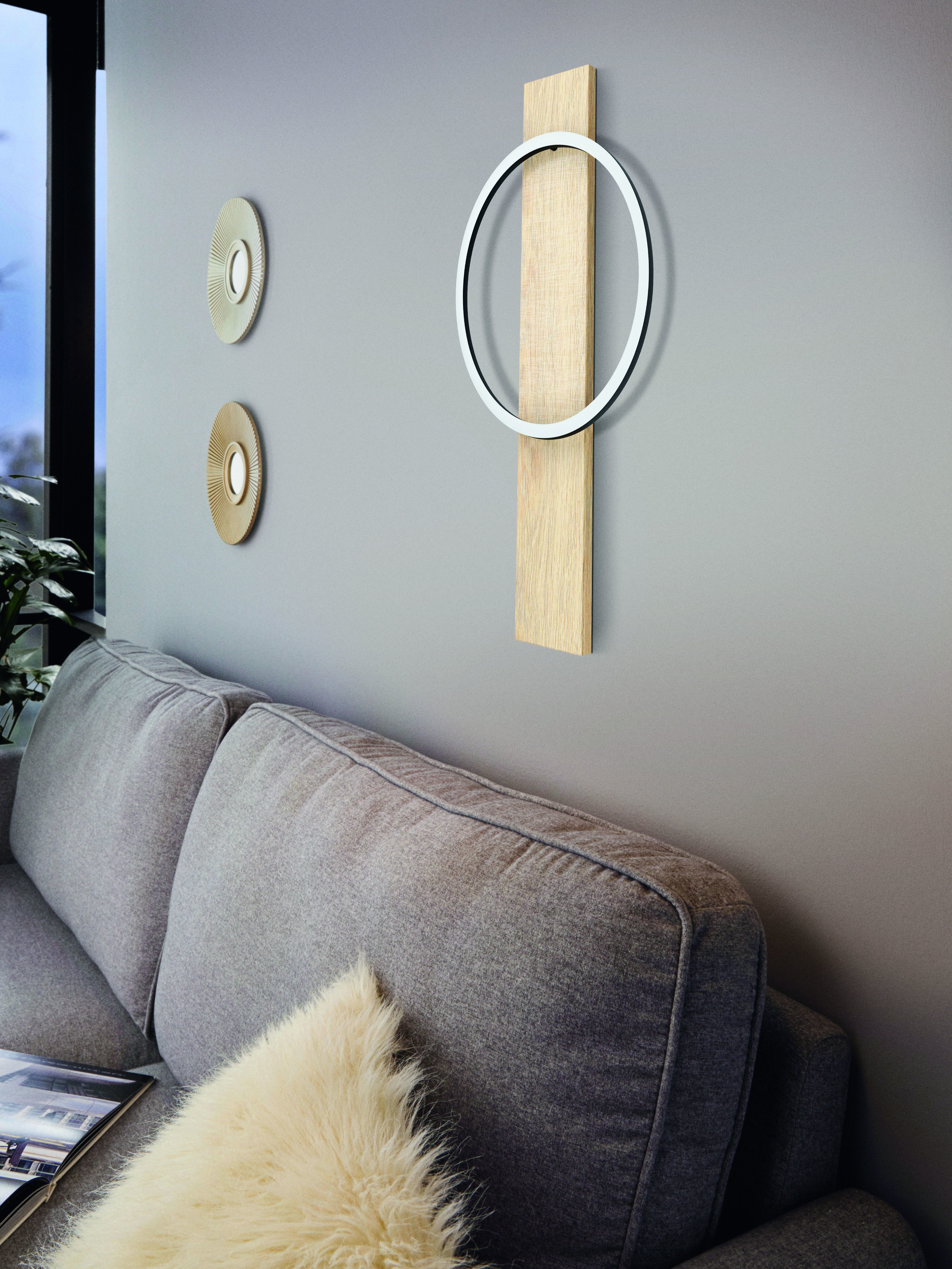 Graue Wand mit dekorativer Wandkunst. Couch im Vordergrund.