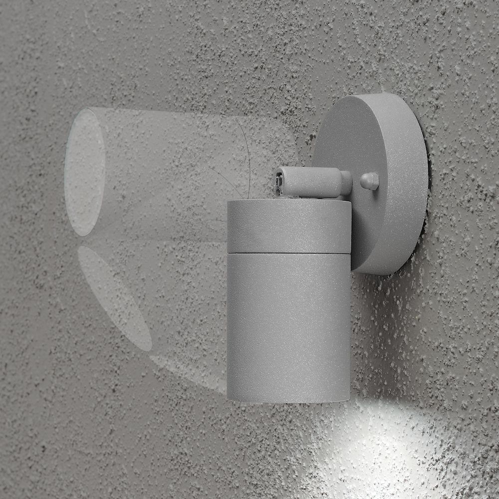 Eine graue Wandlampe, die Licht auf eine raue Wand wirft.