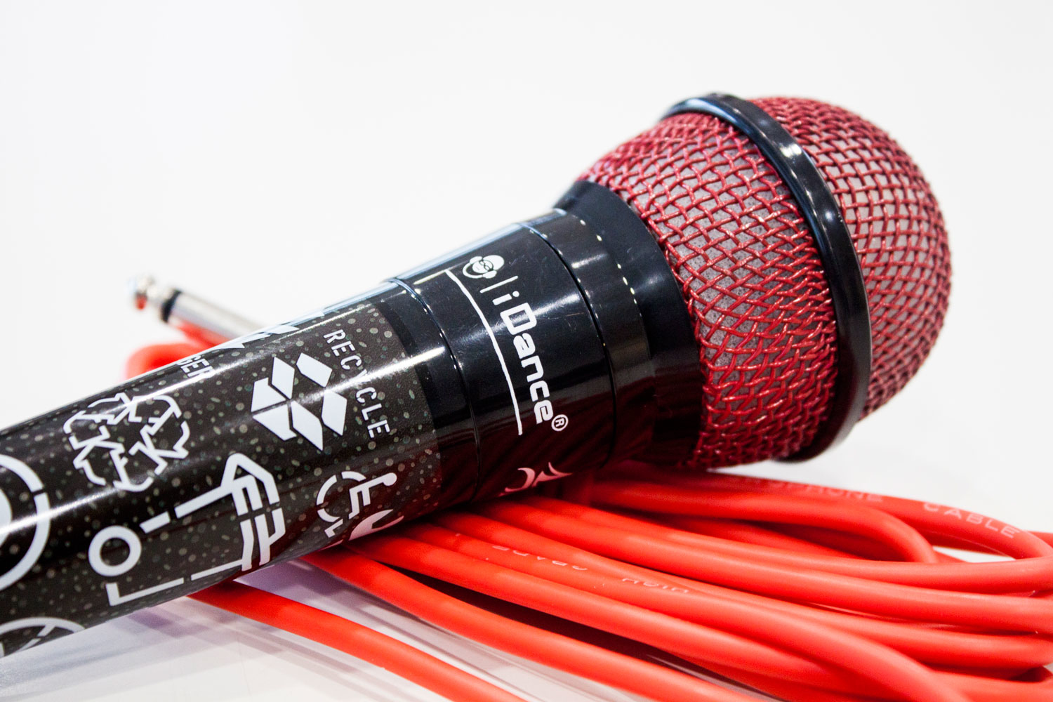 Rotes Mesh-Mikrofon mit rotem Kabel. Das Mikrofon hat ein Recyclingsymbol auf dem schwarzen Griff.