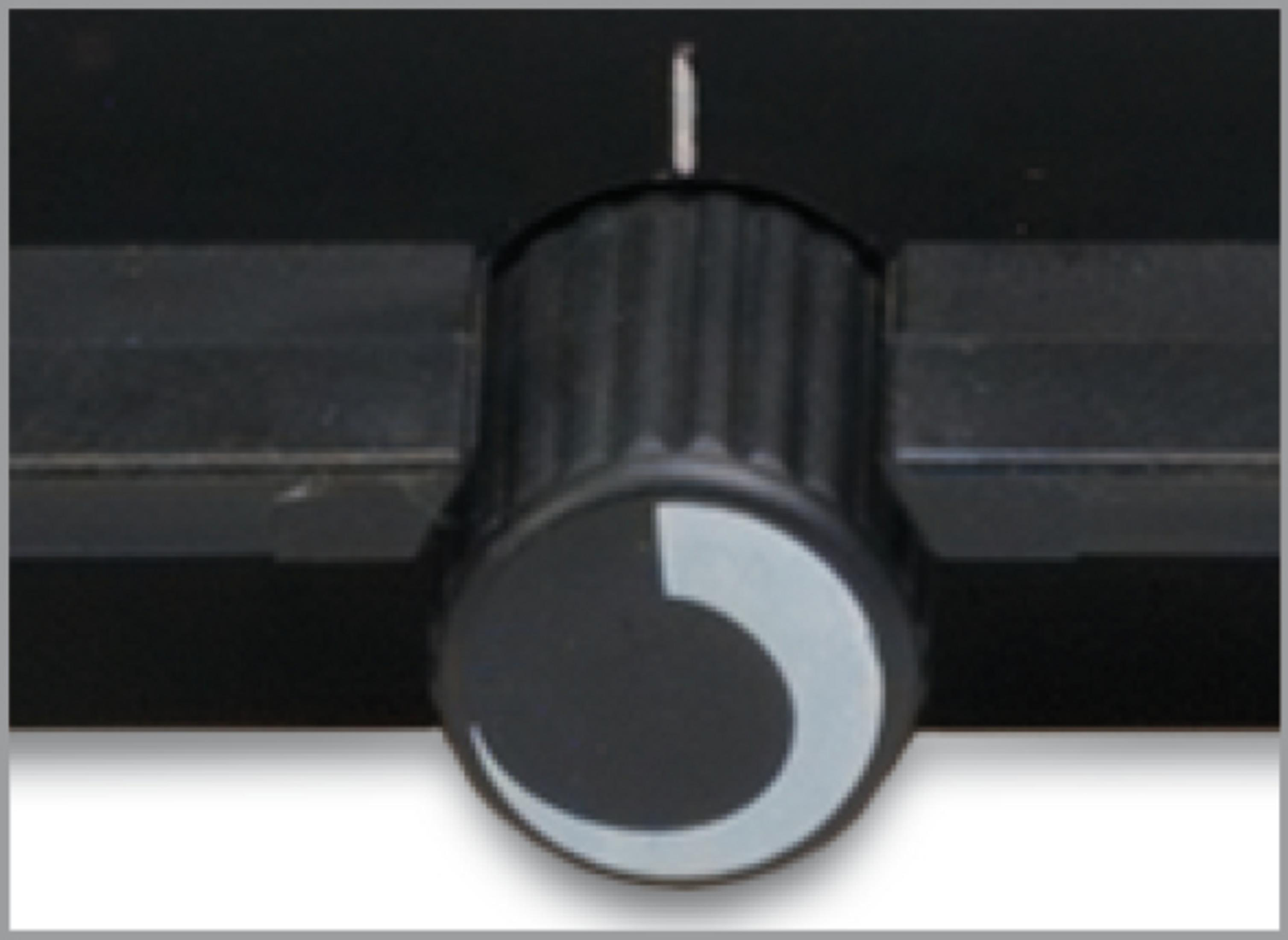 Czarny guzik z białym łukiem na czarnym tle. Guzik jest cylindryczny.