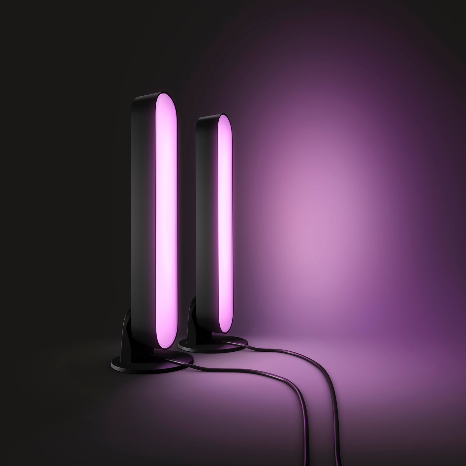 Zwei schwarze und pinkfarbene Philips Hue Play Light Bars auf einem schwarz-lila Farbverlaufshintergrund.