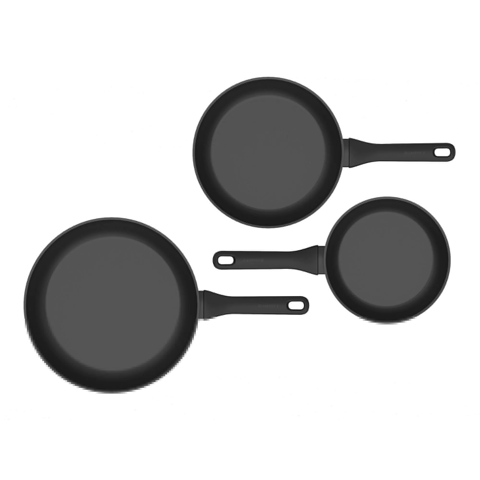 Trois poêles noires sur une surface blanche.