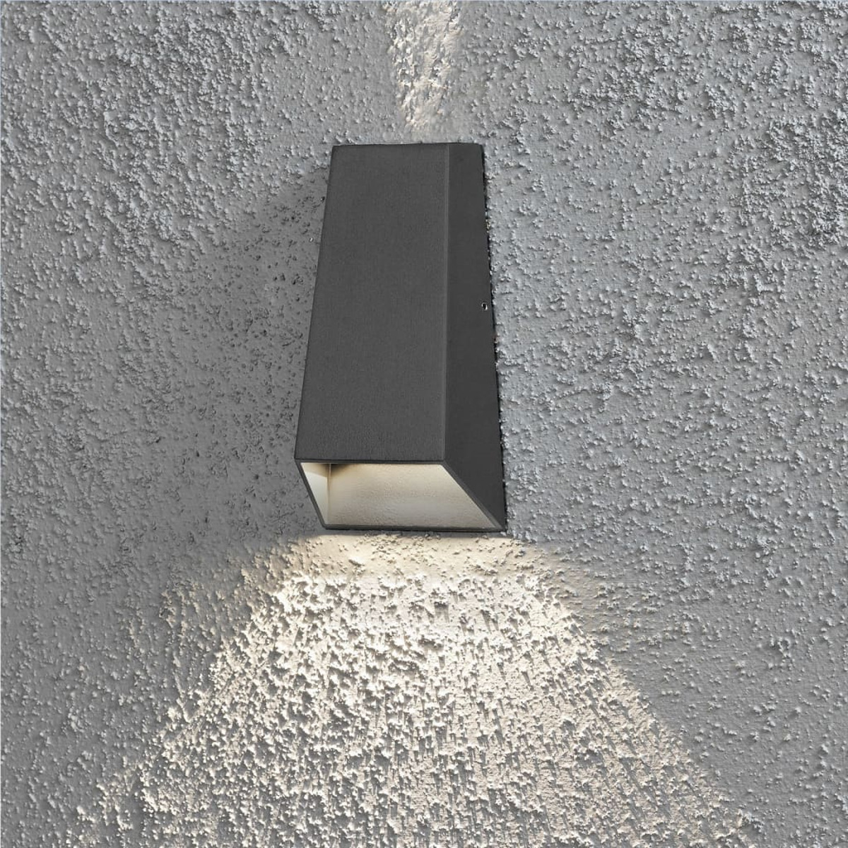 Eine dunkelgraue Wandleuchte an einer strukturierten Wand. Das Licht scheint nach unten.