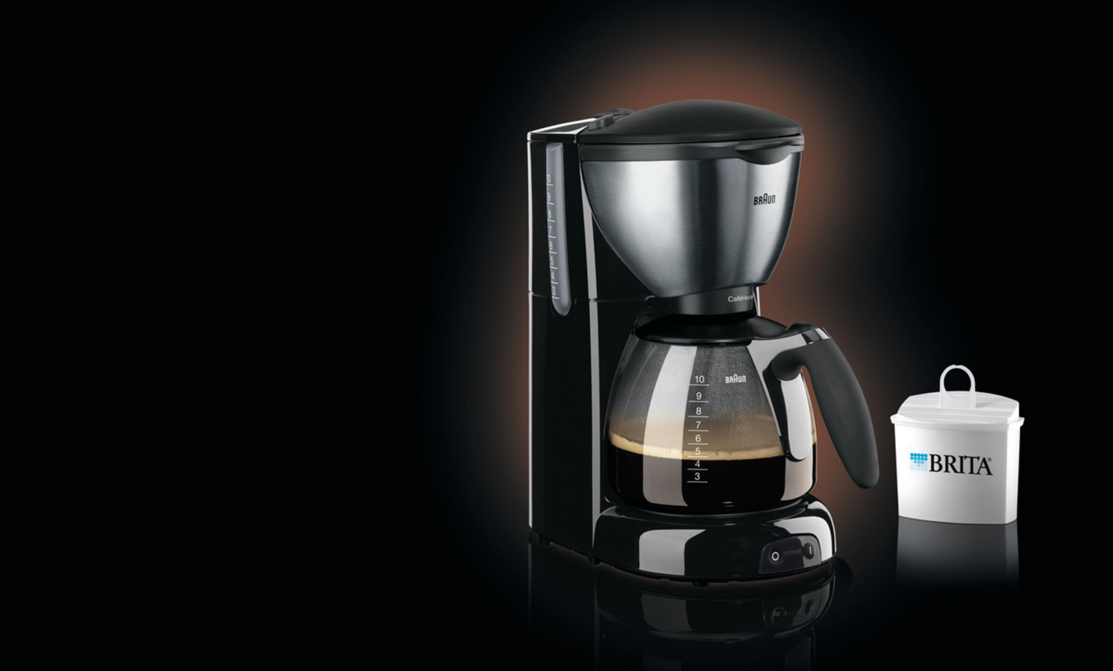 Zwarte en zilveren Braun koffiezetapparaat met koffie. Witte Brita filter. Zwarte achtergrond.
