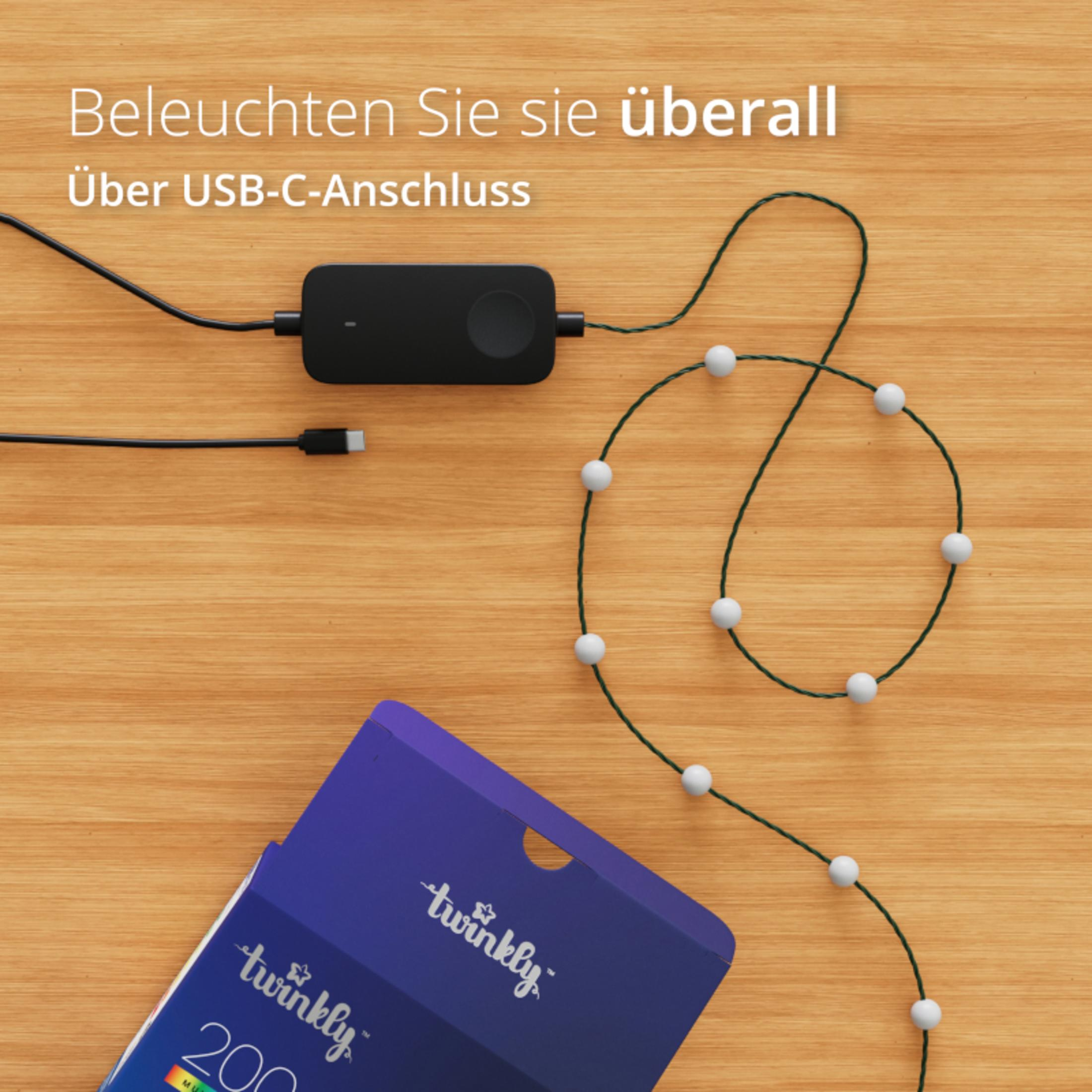 Drewniany stół z czarnym zasilaczem i sznurem białych lampek.