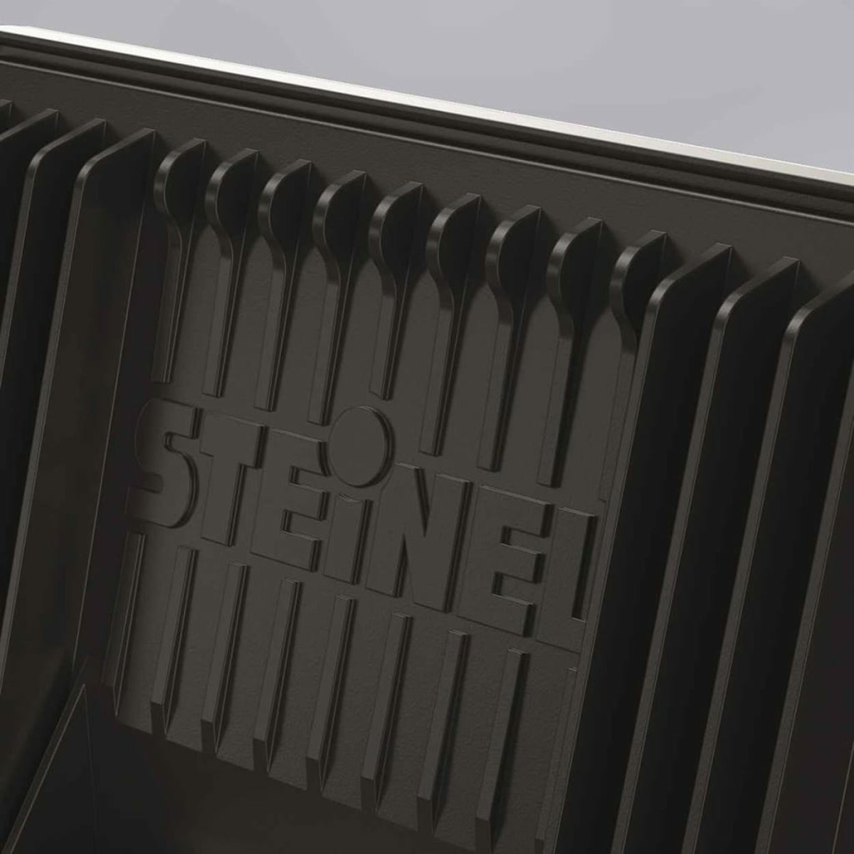 Zbliżenie czarnej metalowej konstrukcji marki SteineI z pionowymi liniami. Struktura jest ciemna.