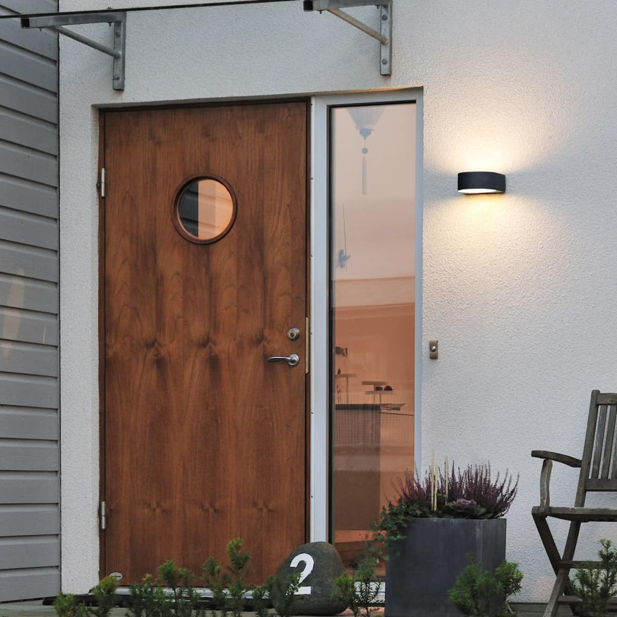 Una porta marrone e un muro con lampada.