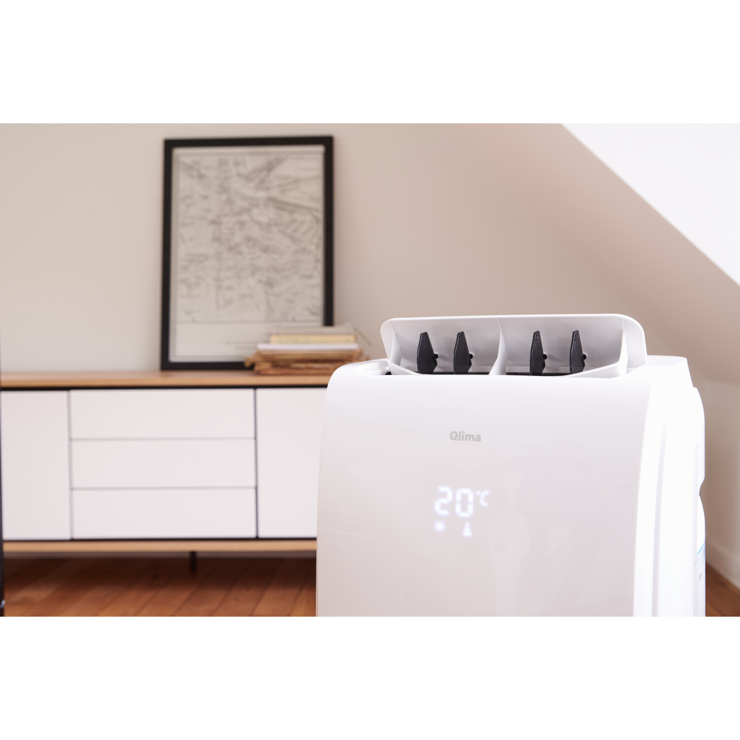 White air conditioner with a digital display showing 20°C. Furniture in the background.