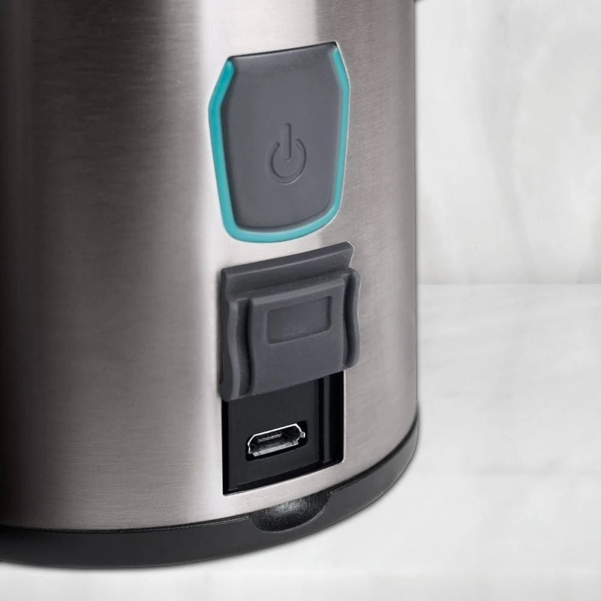 Zbliżenie srebrnego urządzenia z przyciskiem zasilania i portem USB.