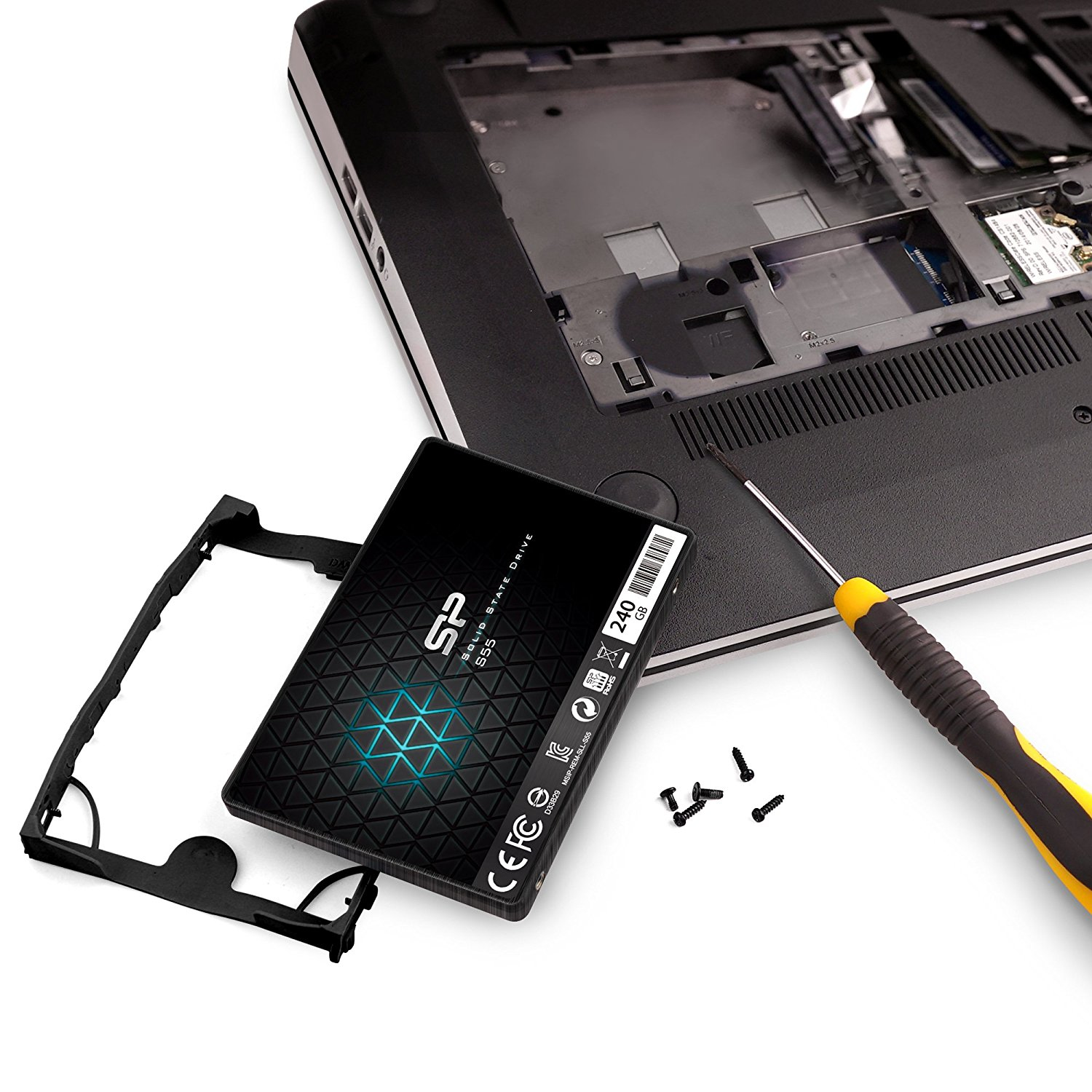 SSD e cacciavite su un laptop. SSD nera con cornice, viti e cacciavite giallo e nero.