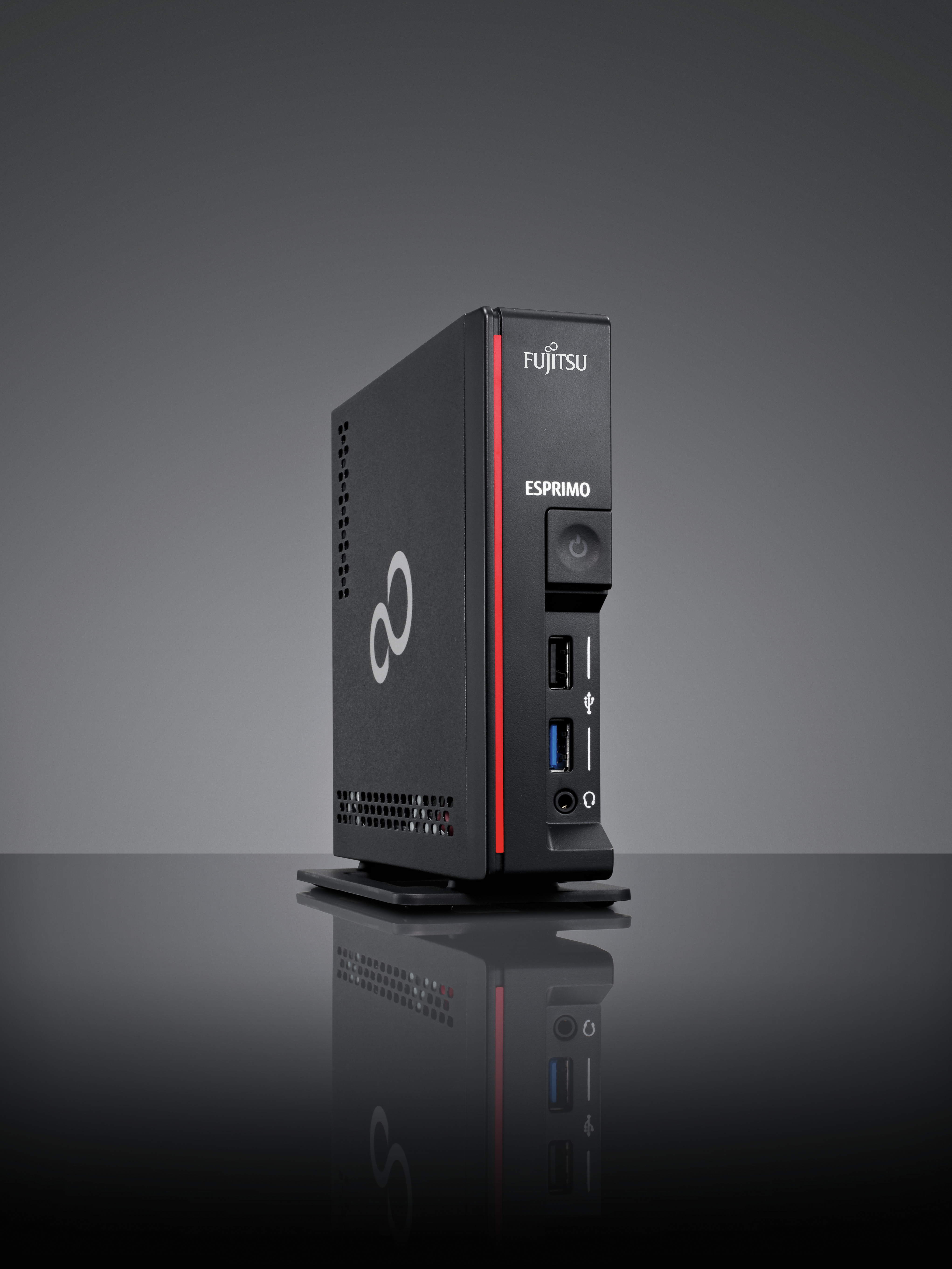 Black Fujitsu Esprimo PC, angled view. Red stripe, on a reflective surface.