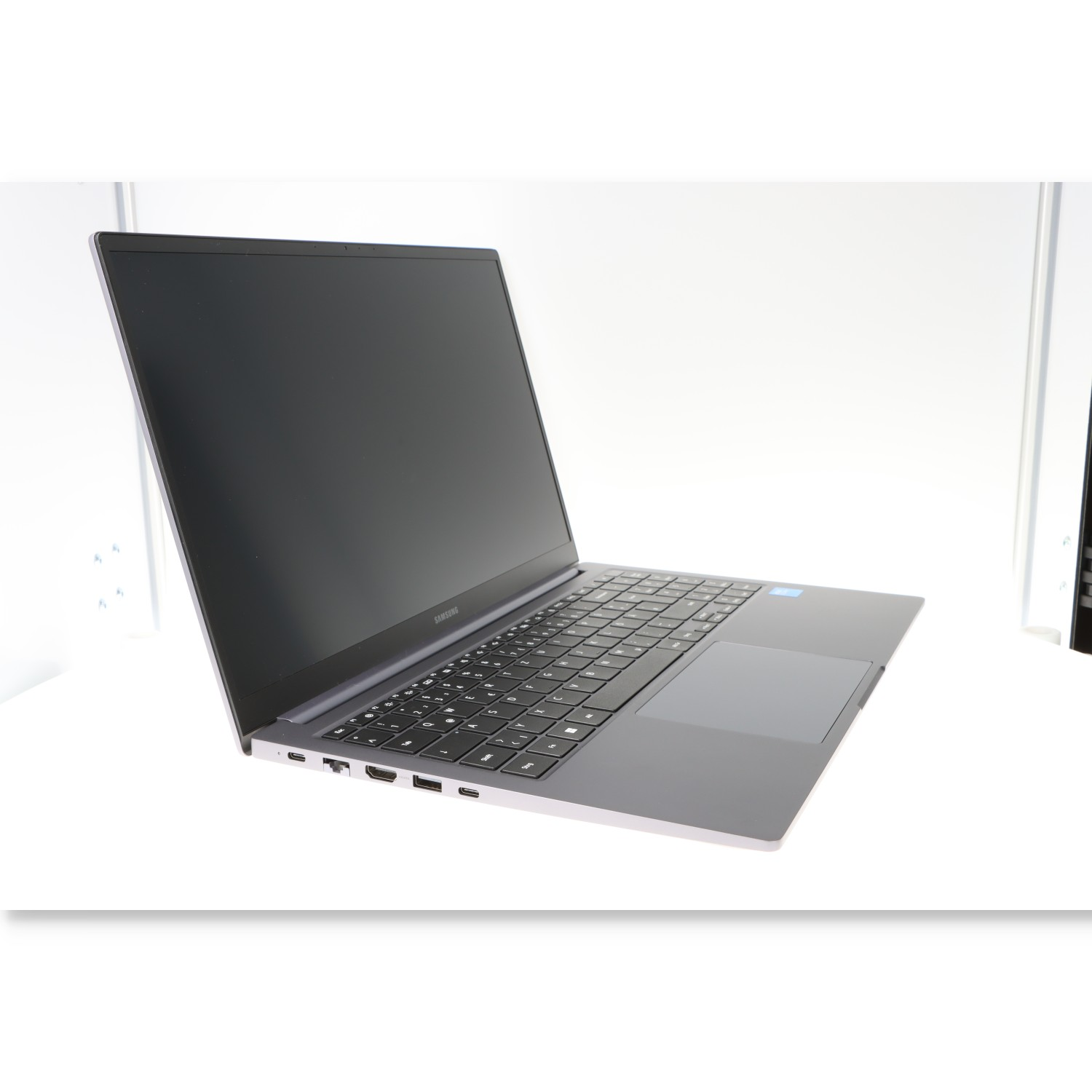Laptop auf weißer Oberfläche. Schwarzer Bildschirm, silbernes Gehäuse. Isoliert, offen.