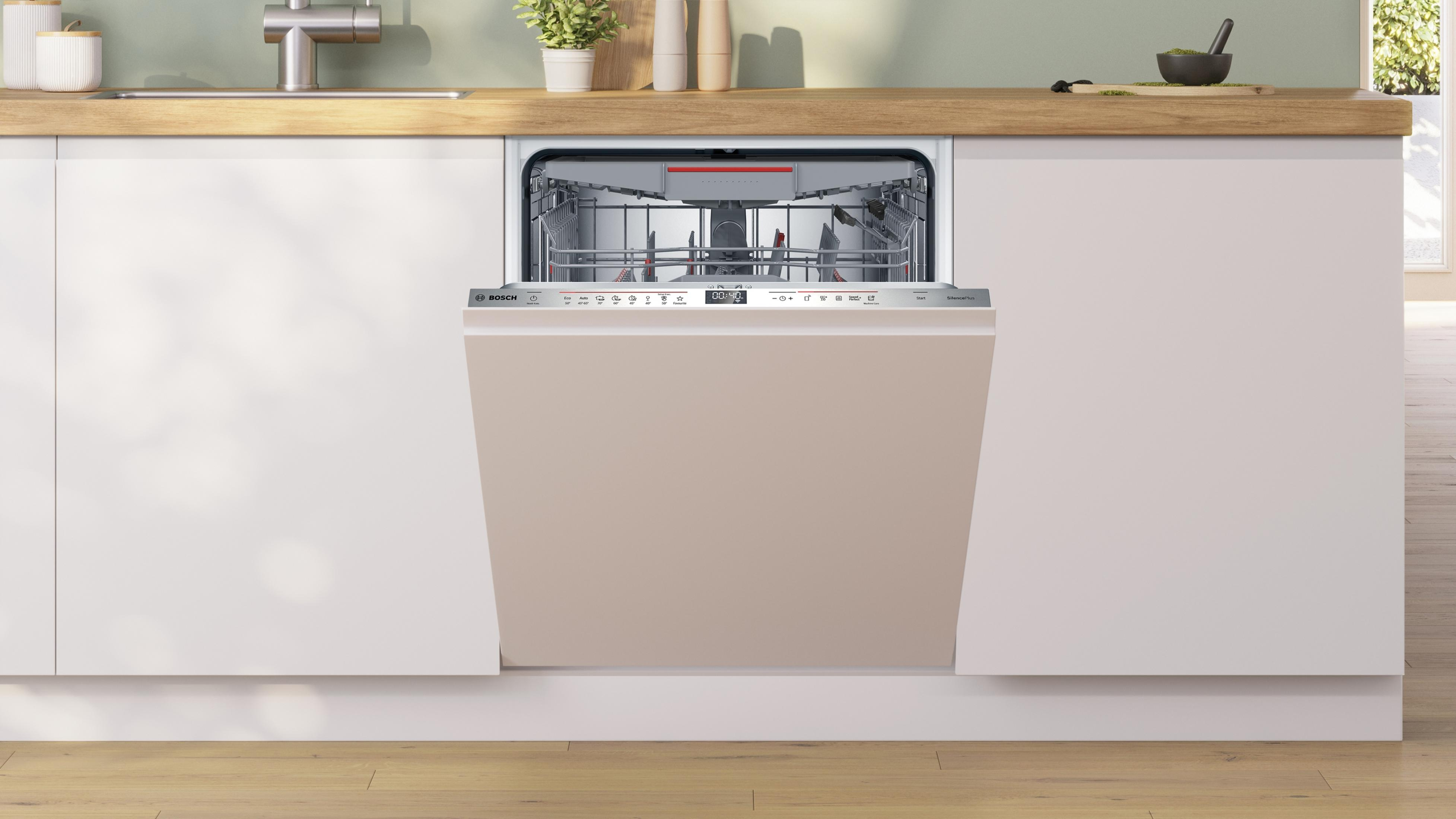 Una lavastoviglie a incasso in una cucina con mobili bianchi.
