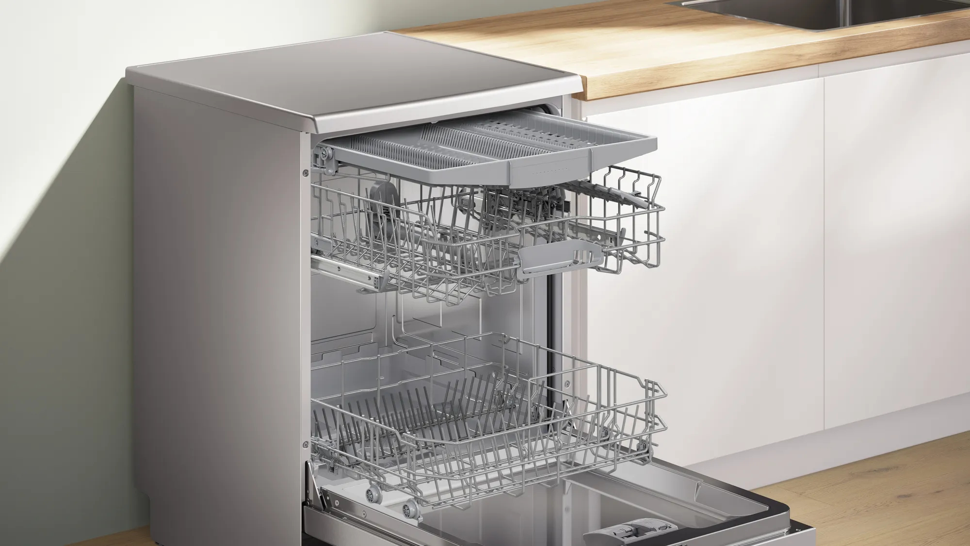 Zmywarka z otwartymi drzwiami, pokazująca kosze. Górny kosz wysunięty, prawie pusty.